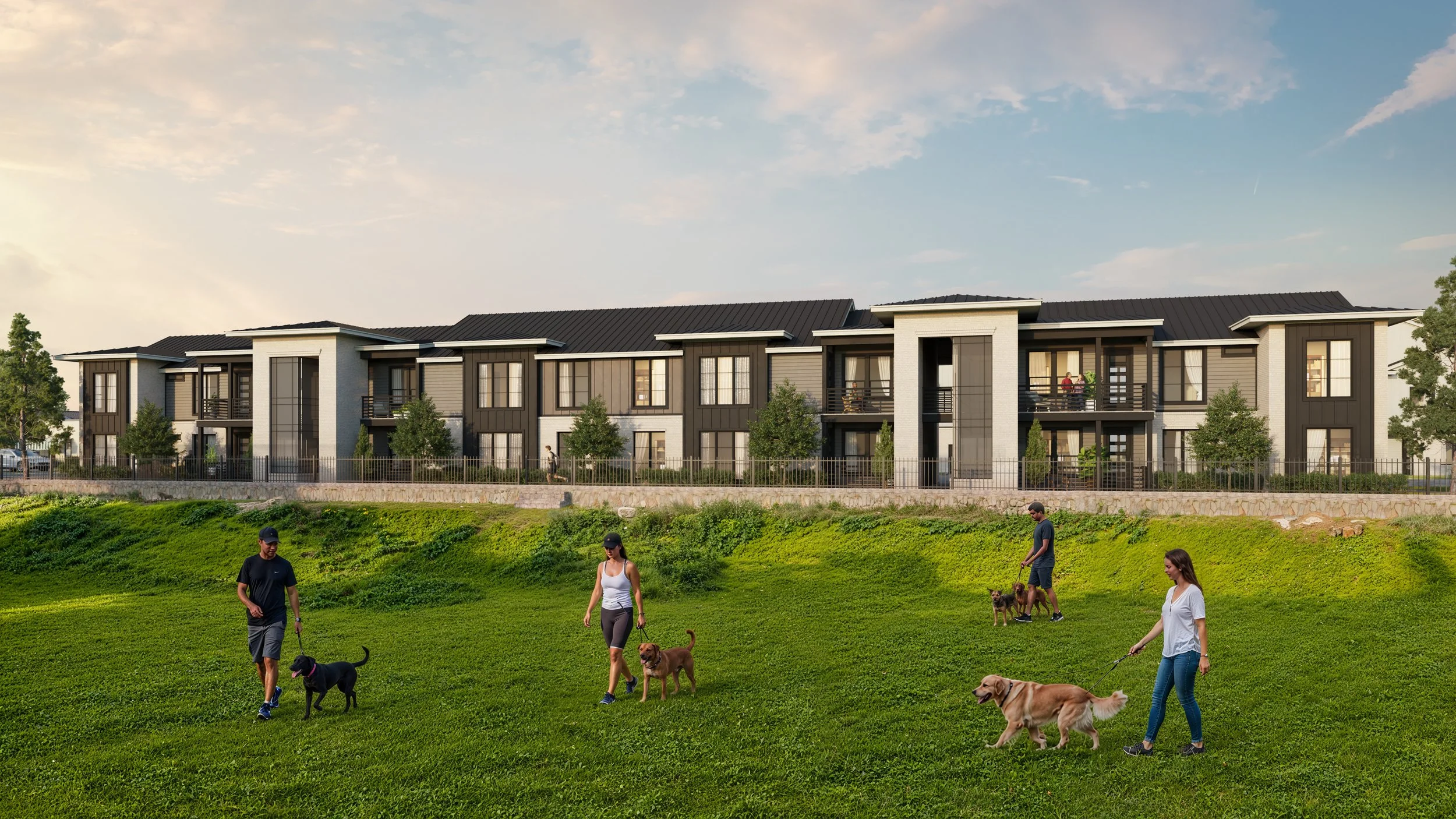 People walking their dogs on a grassy area in front of a modern residential building with multiple units and balconies.
