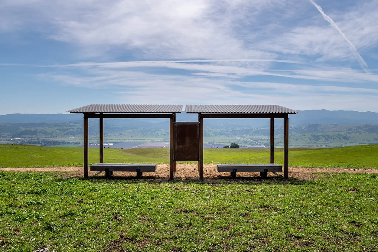 Open-air shelter with seating on the grassy ridge at Máyyan 'Ooyákma