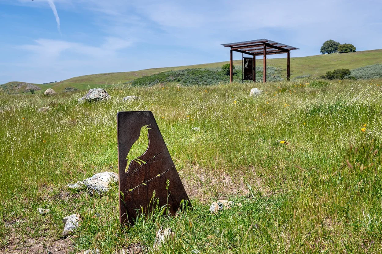 Weathered steel interpretive sign with a bird cutout at Coyote Ridge
