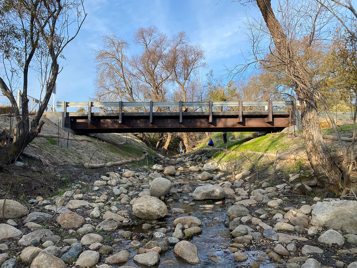 Steel bridge spanning the rebuilt rocky channel at the Tomato Stand fish passage project
