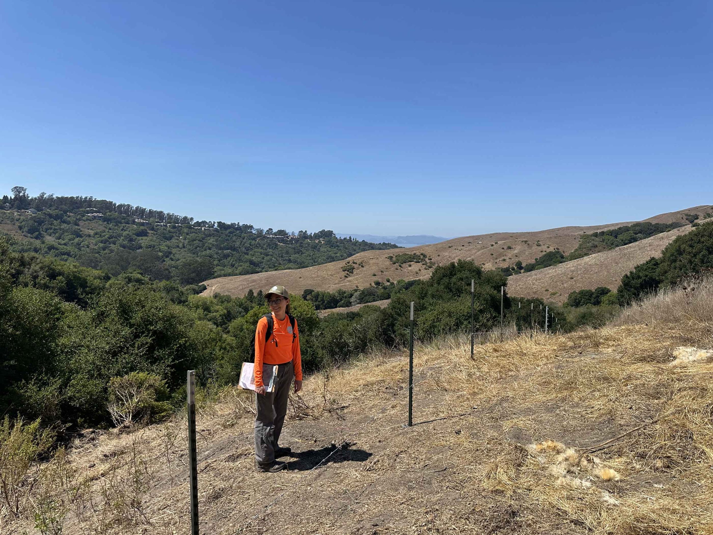 RDG team member walking a trail on a grassy hillside at Havey Canyon