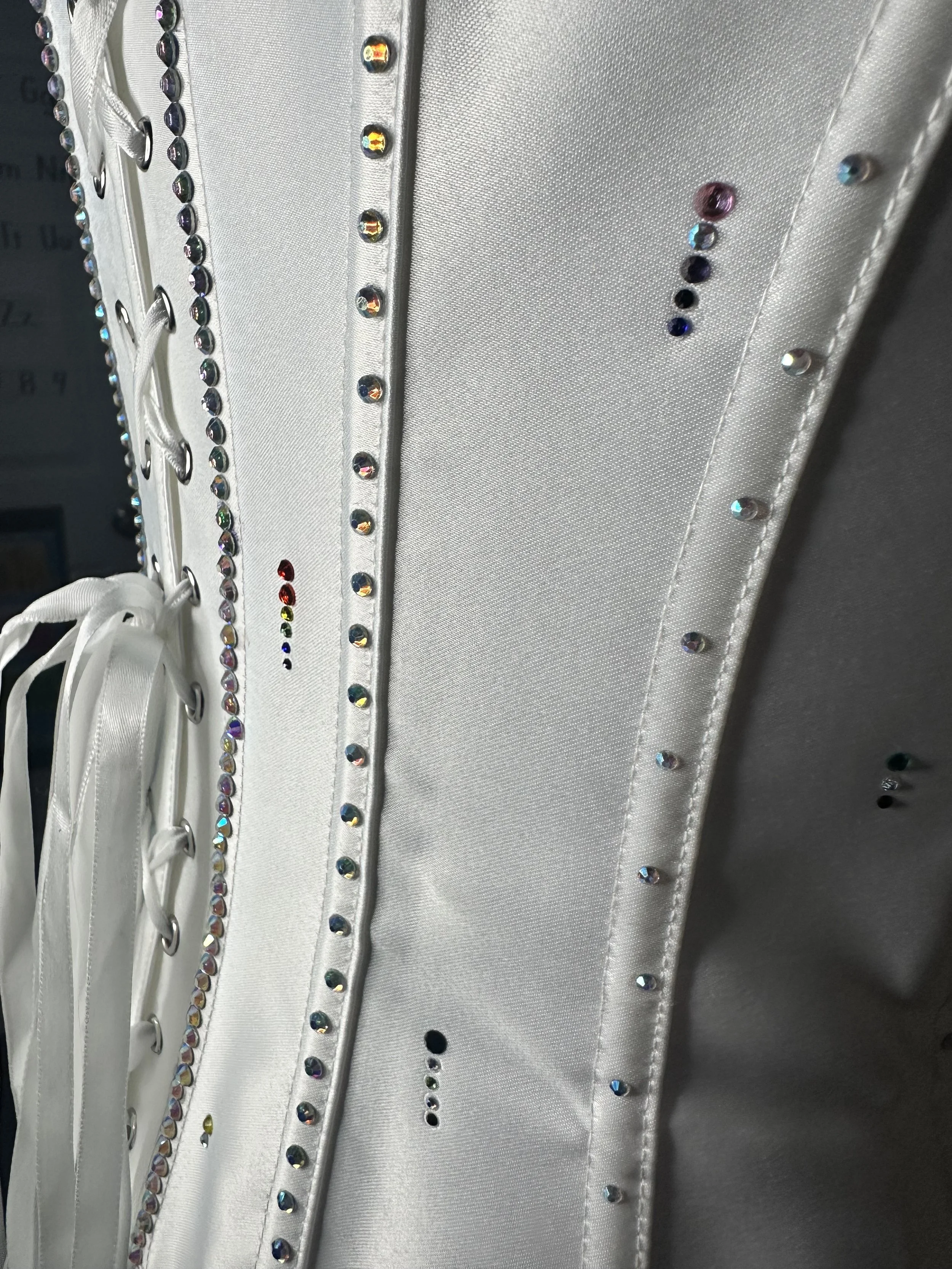 Close-up of a white fabric with decorative rhinestones arranged in parallel rows.