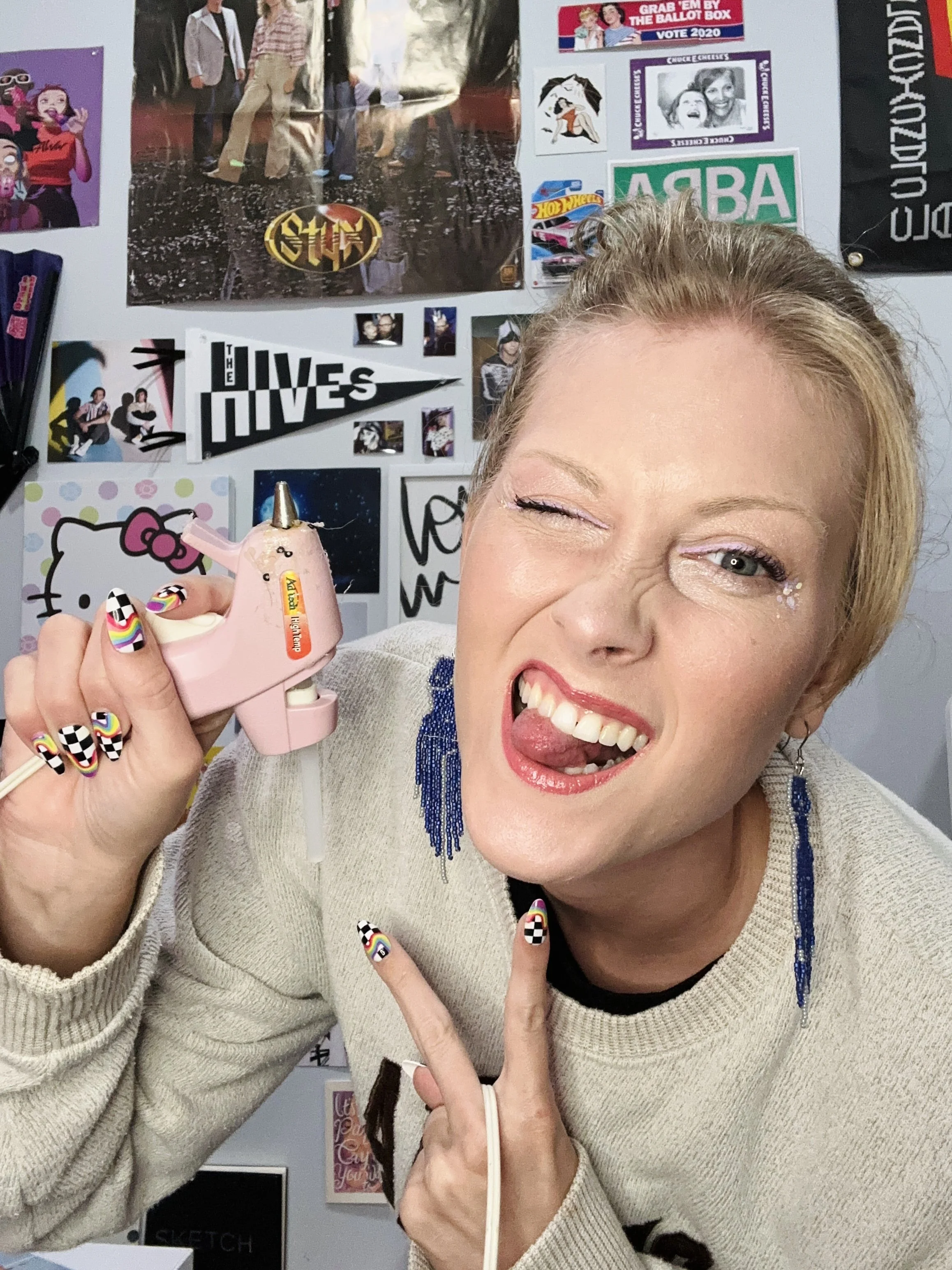 Paige DeLozier with a glue gun and pop culture wall