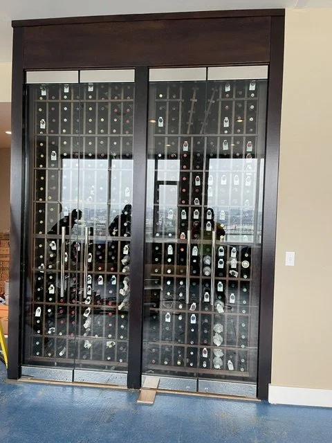 Glass cabinet filled with wine bottles.