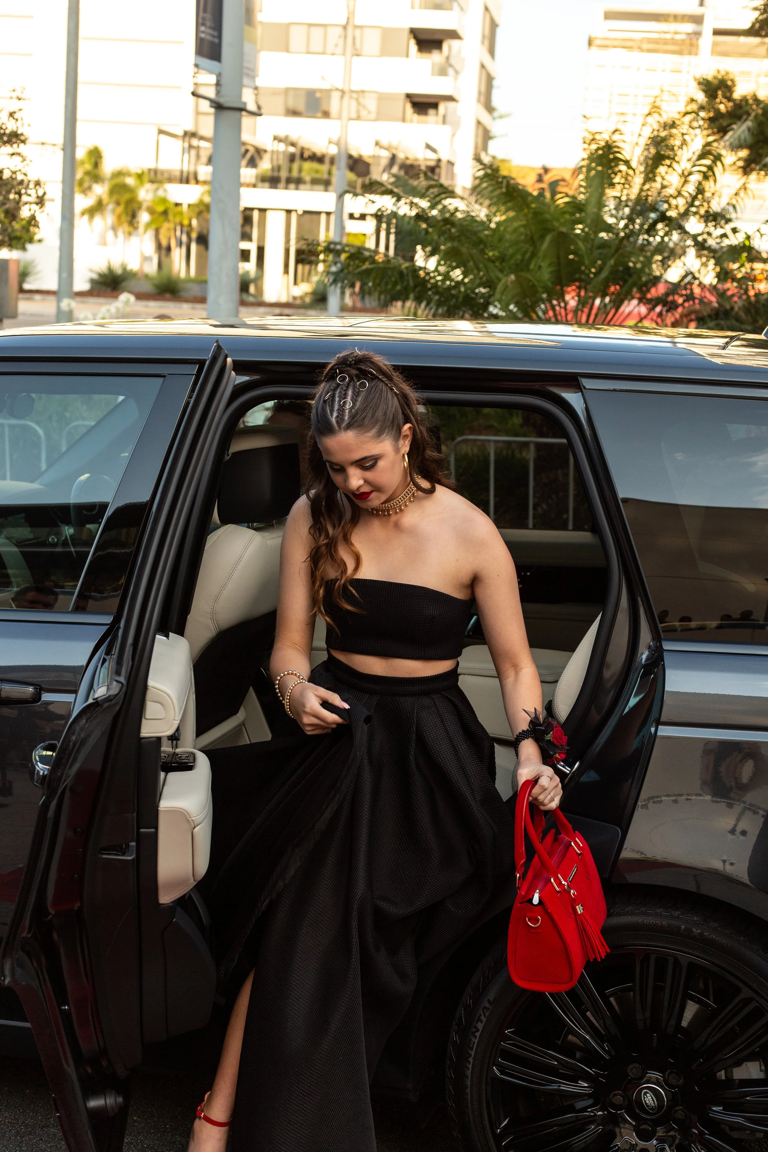 Formal student getting out of vintage car at the red carpet.