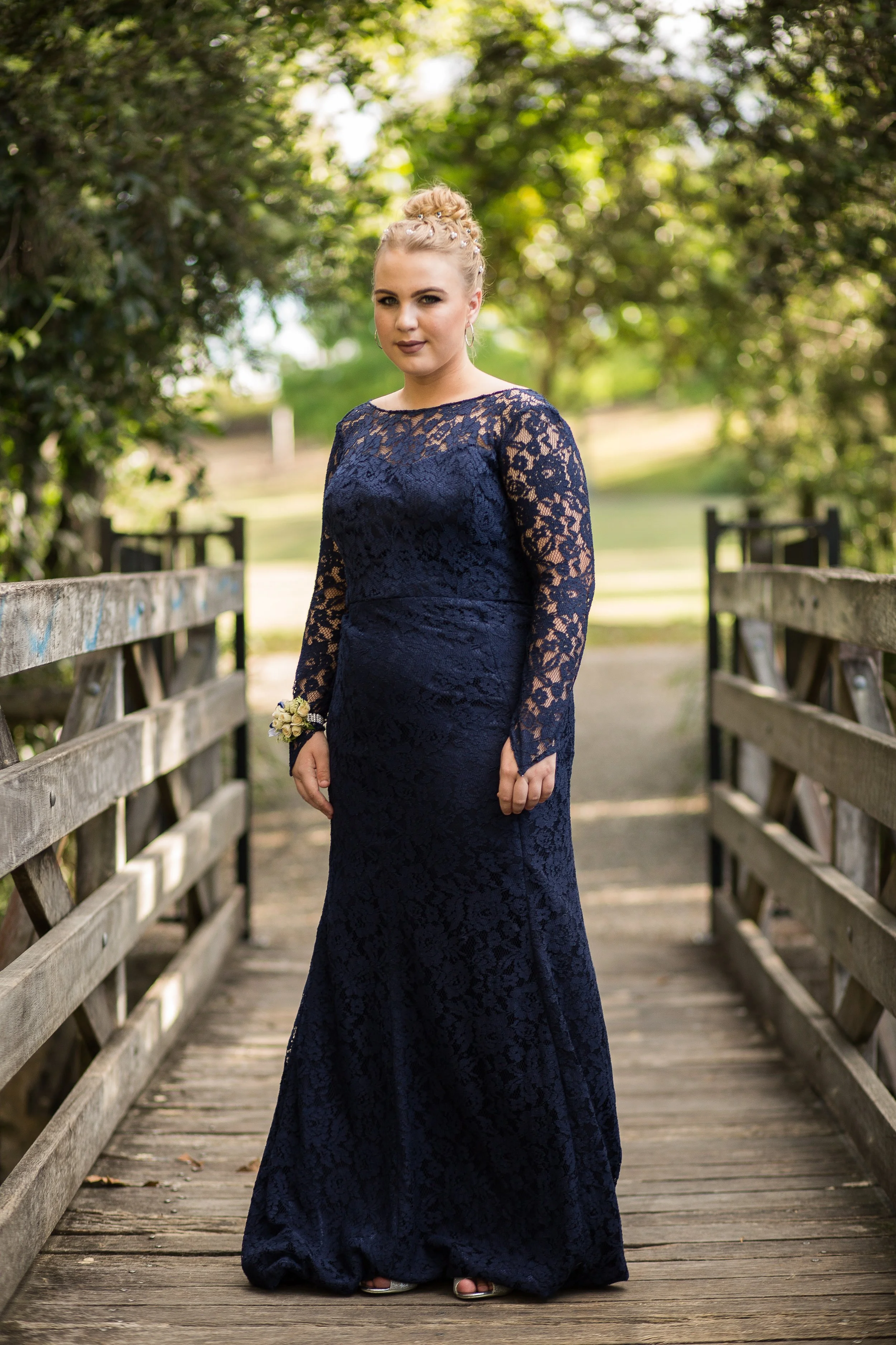 Female portrait for school formal on timber bridge in natural golden light.