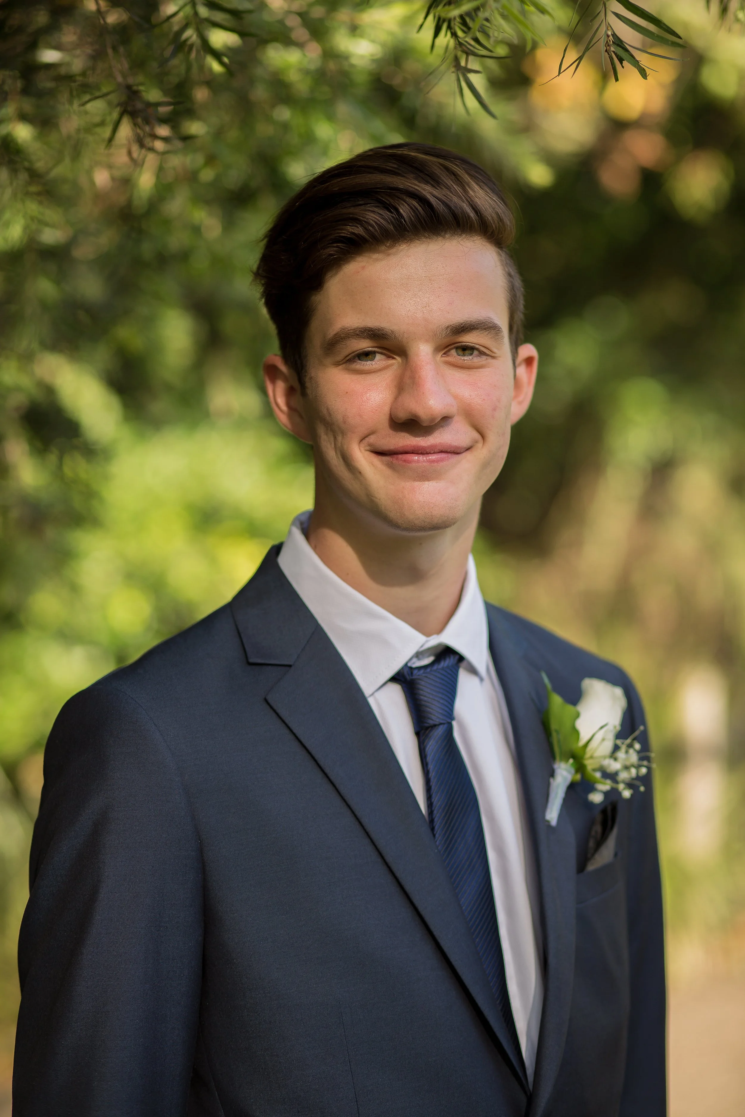 Formal headshot of student with natural golden light in local park.