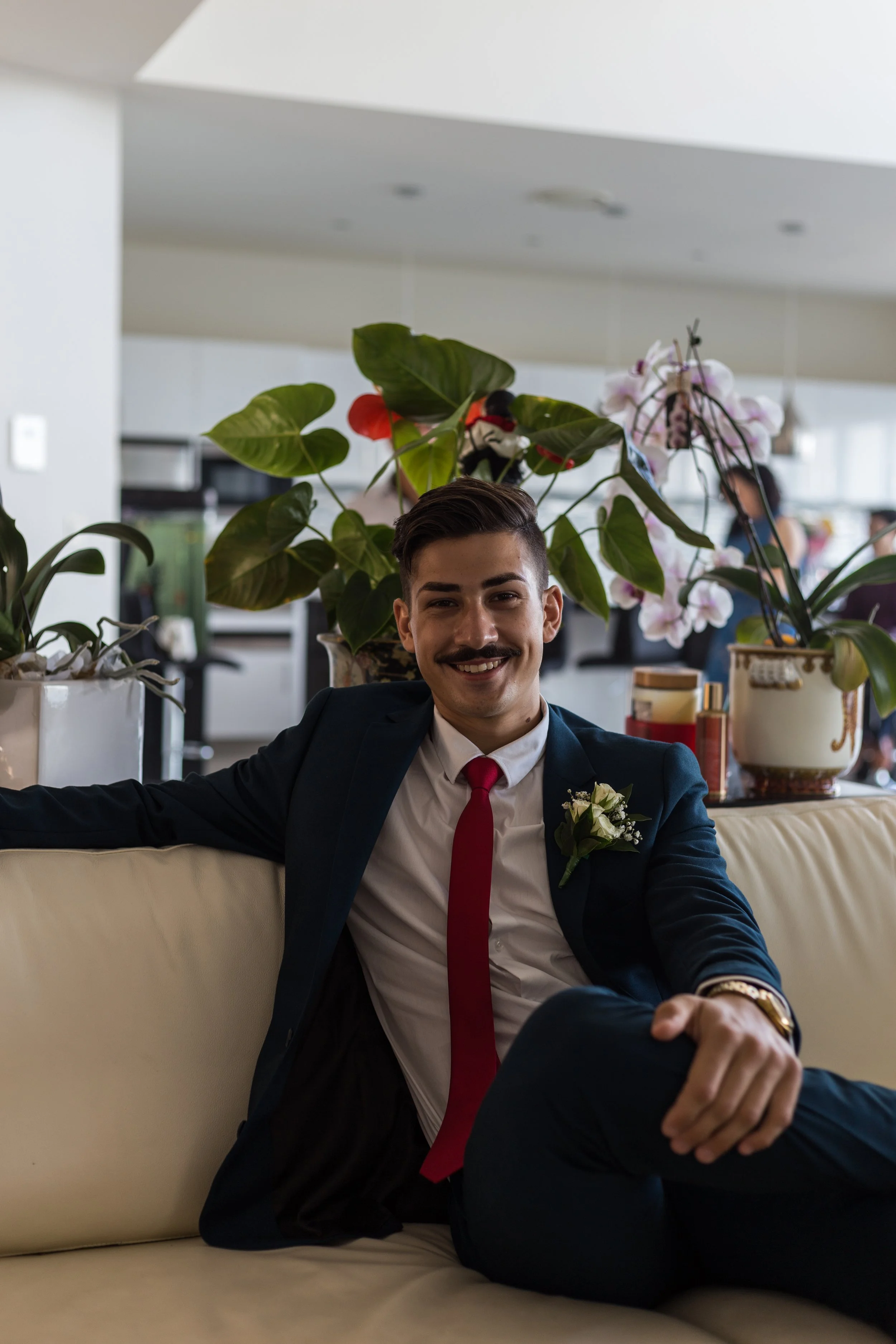 Male sitting on couch posing for a portrait in a natural sunlit room. 