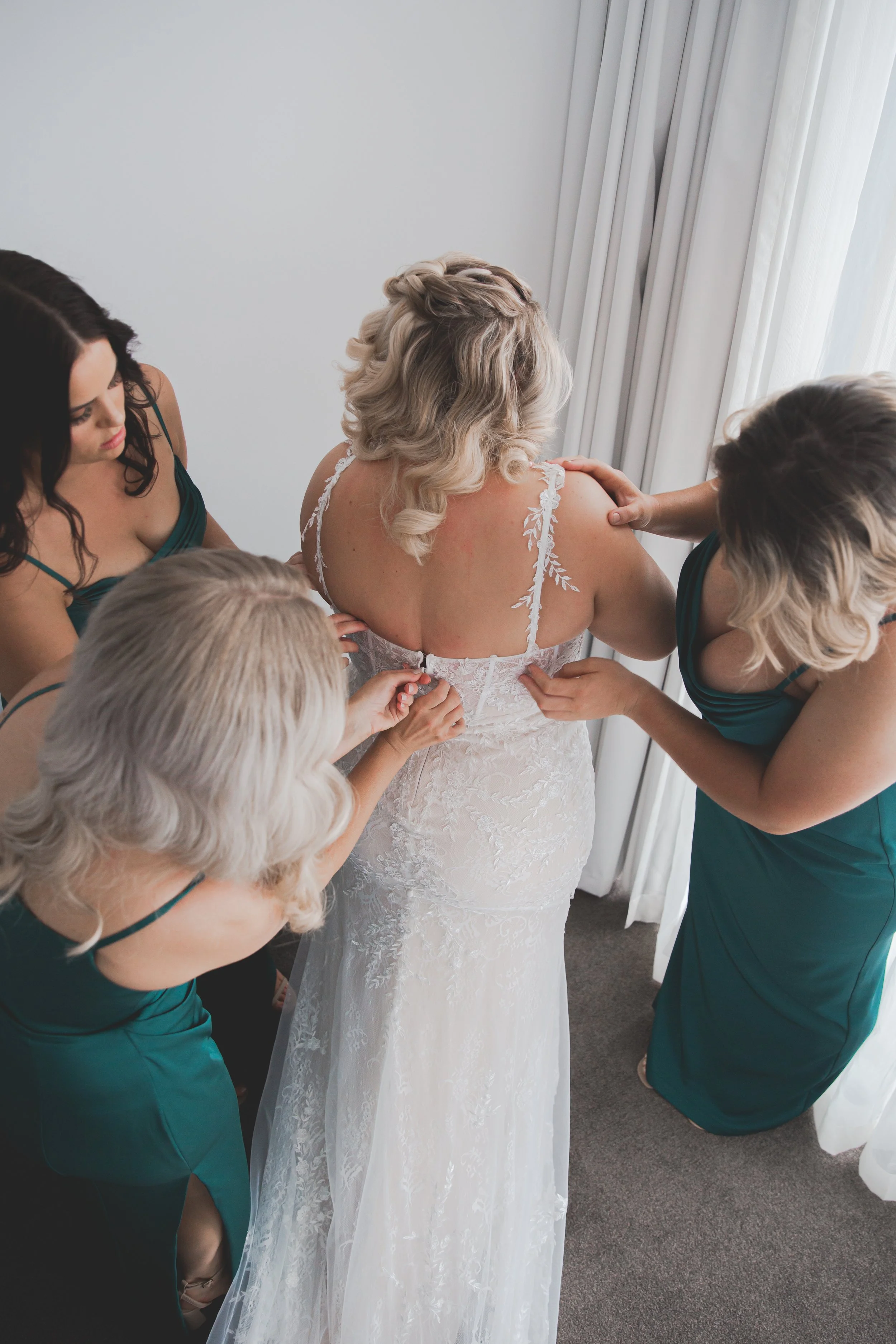 Bride getting helped into wedding dress by bridesmaids at Peppers Broadbeach.  