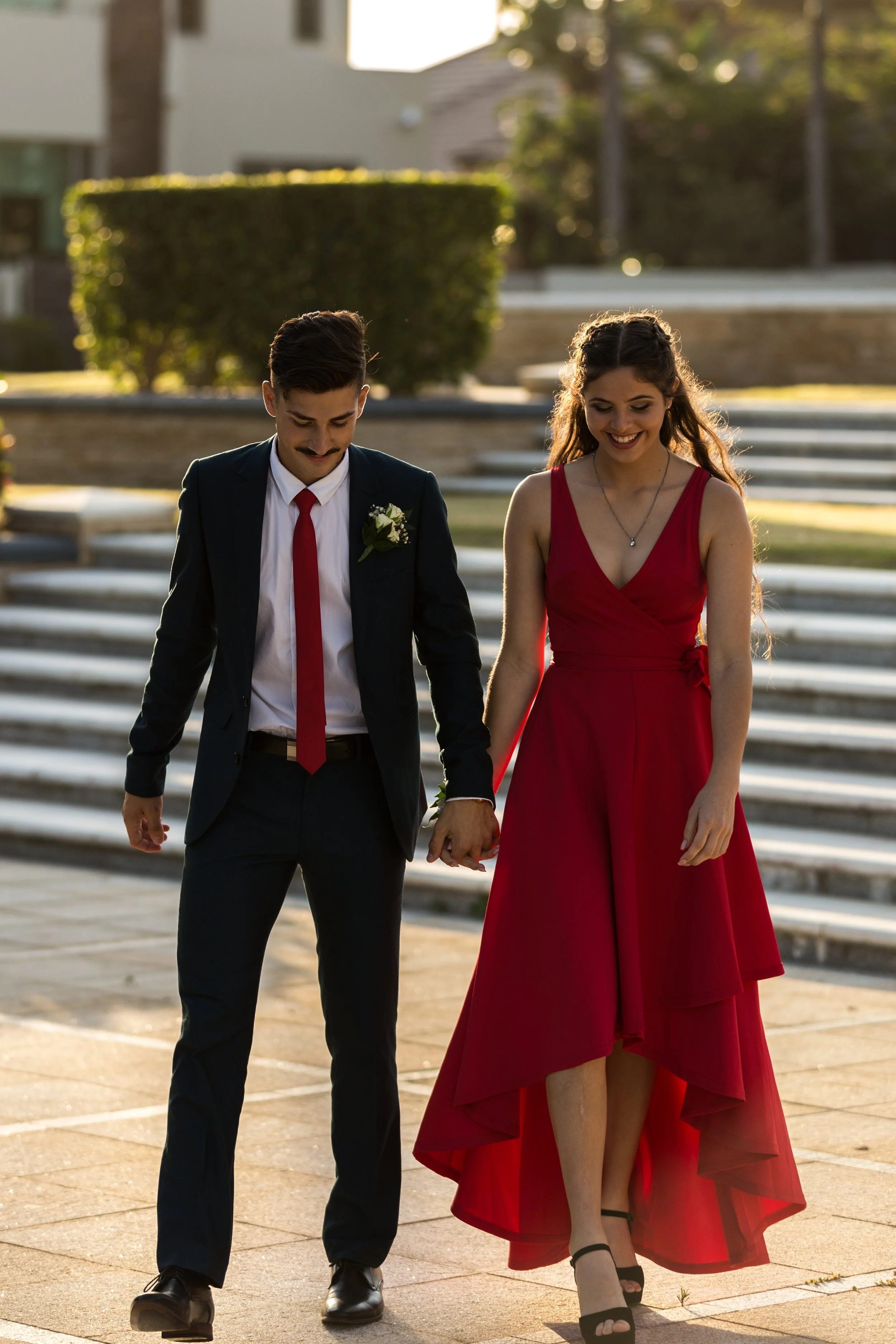 Couple formal students walking in Sovereign Island during golden sunset.