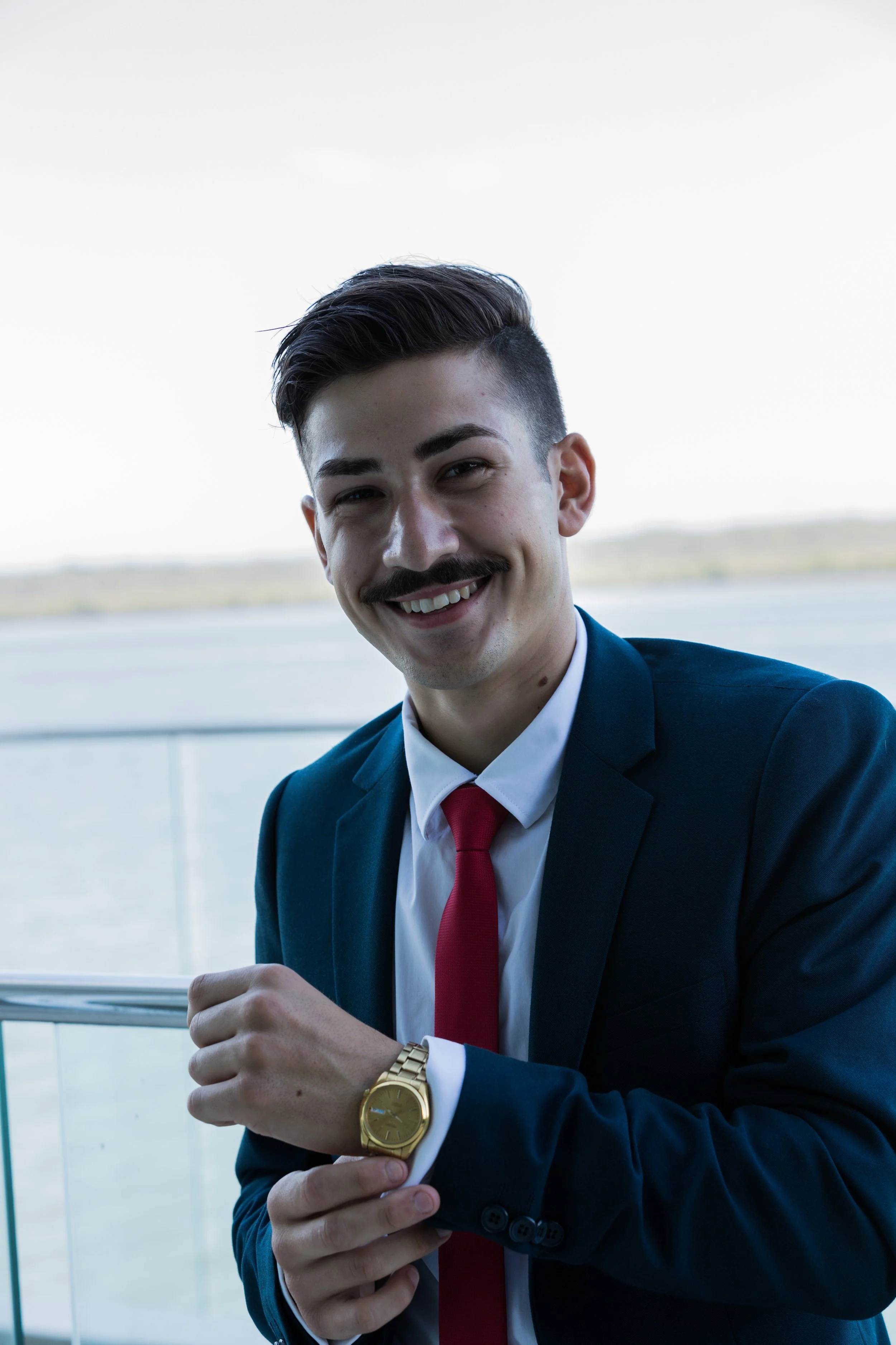 Portrait of school formal student adjust a wrist watch at a beach front mansion in Sovereign Island. 
