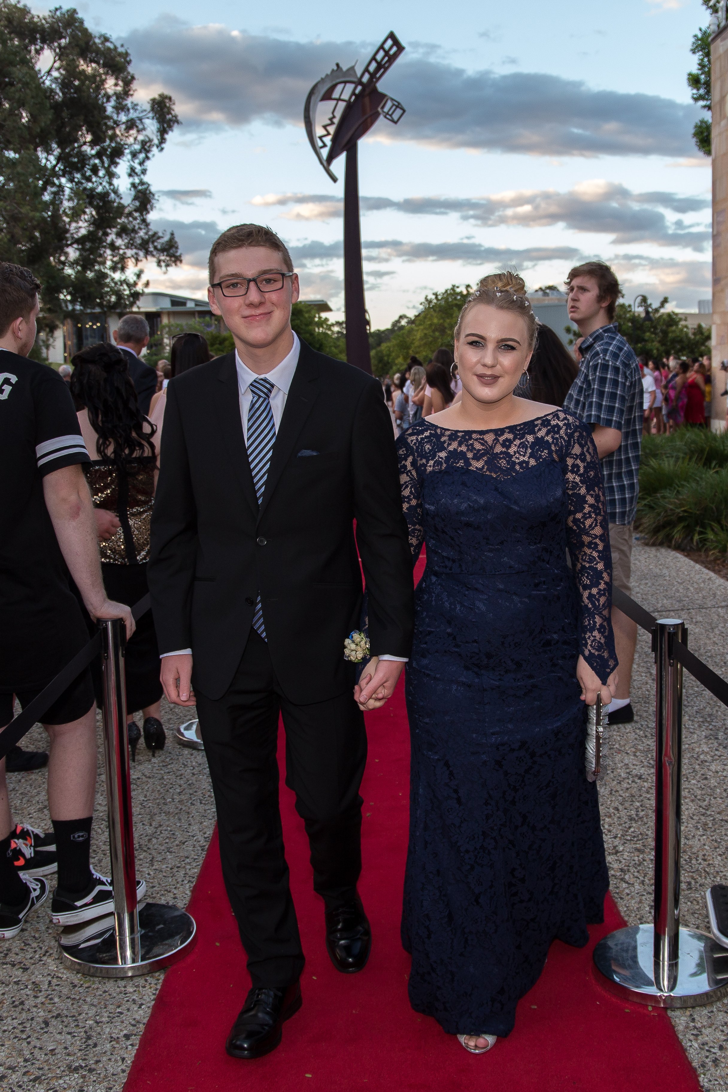 Formal students walk down red carpet on arrival at Bond university. 