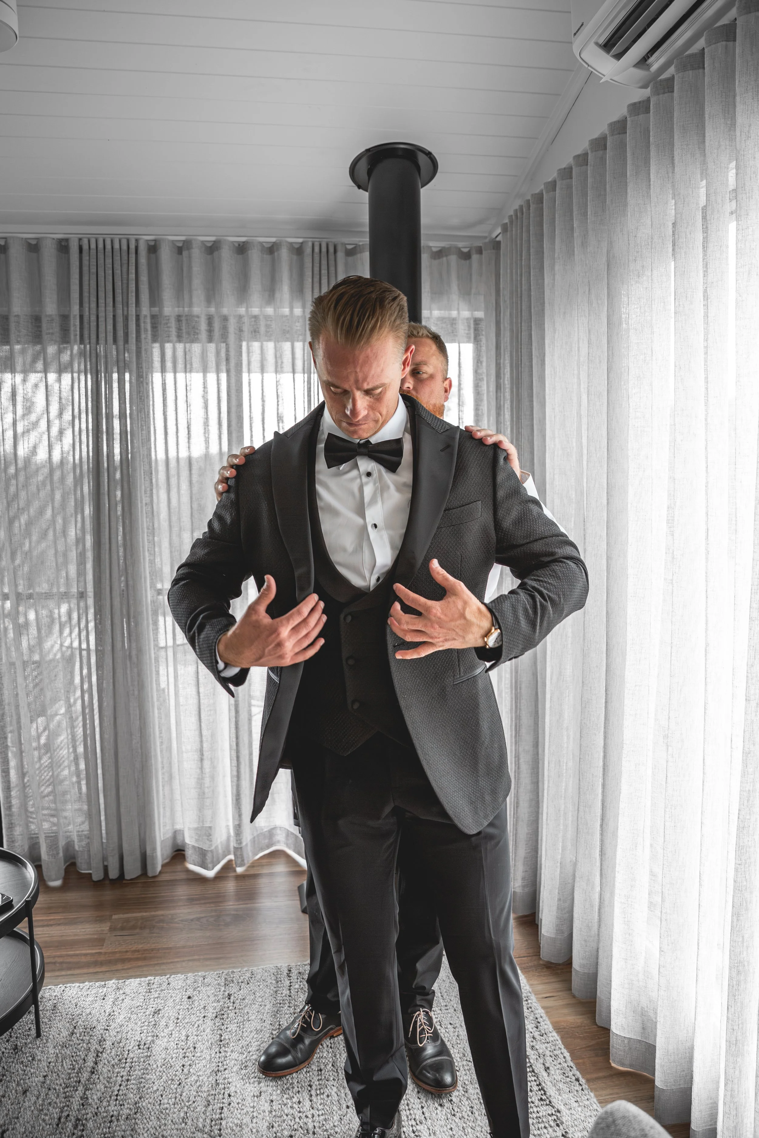 Groom putting jacket on with groomsmen at Selah Valley Estate Hillside Cabins.
