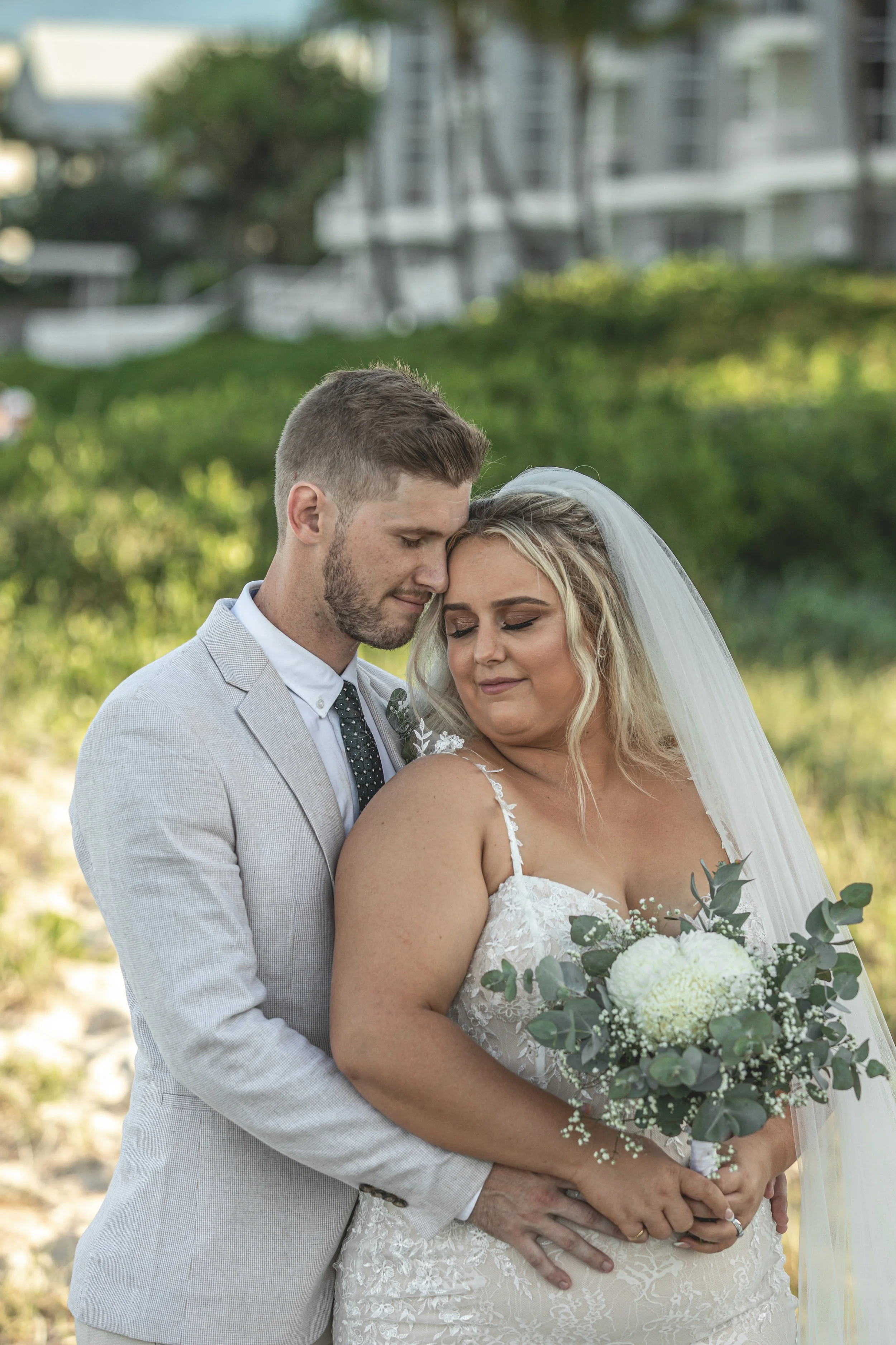 Couple sharing intimate moment on Gold Coast beach during wedding. 