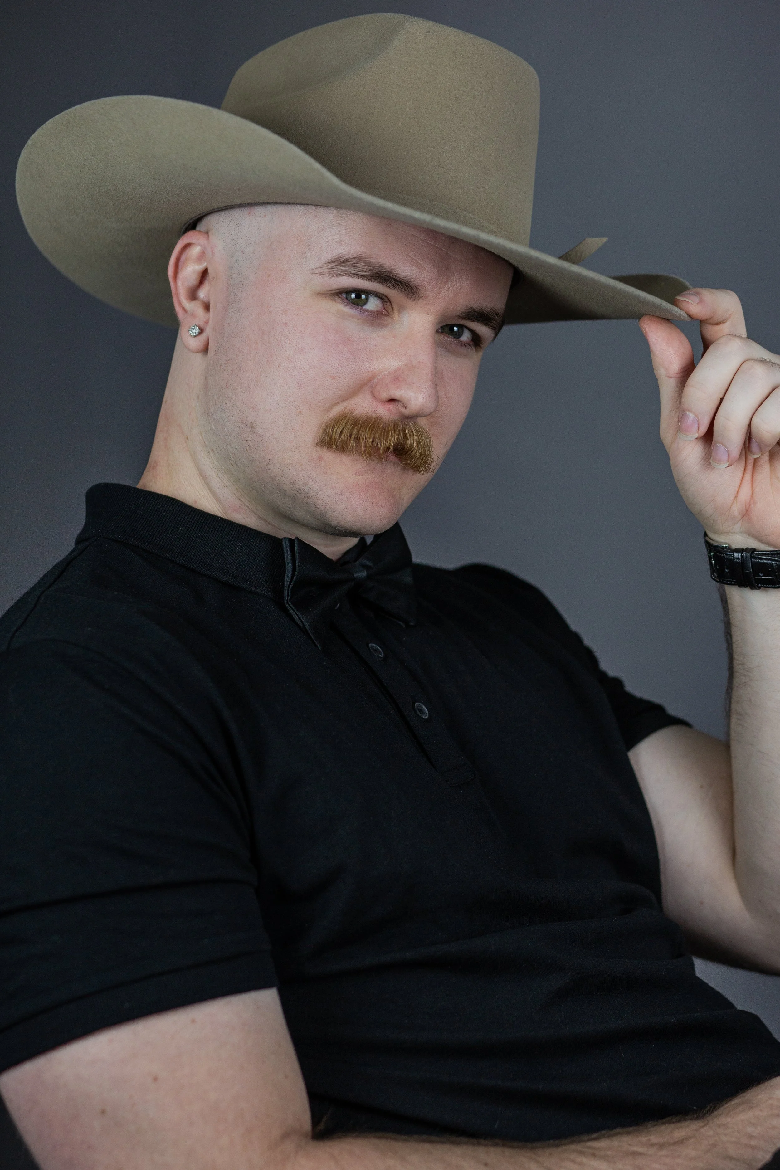 Furlonger Images poses in studio wearing bowtie and cowboy hat.