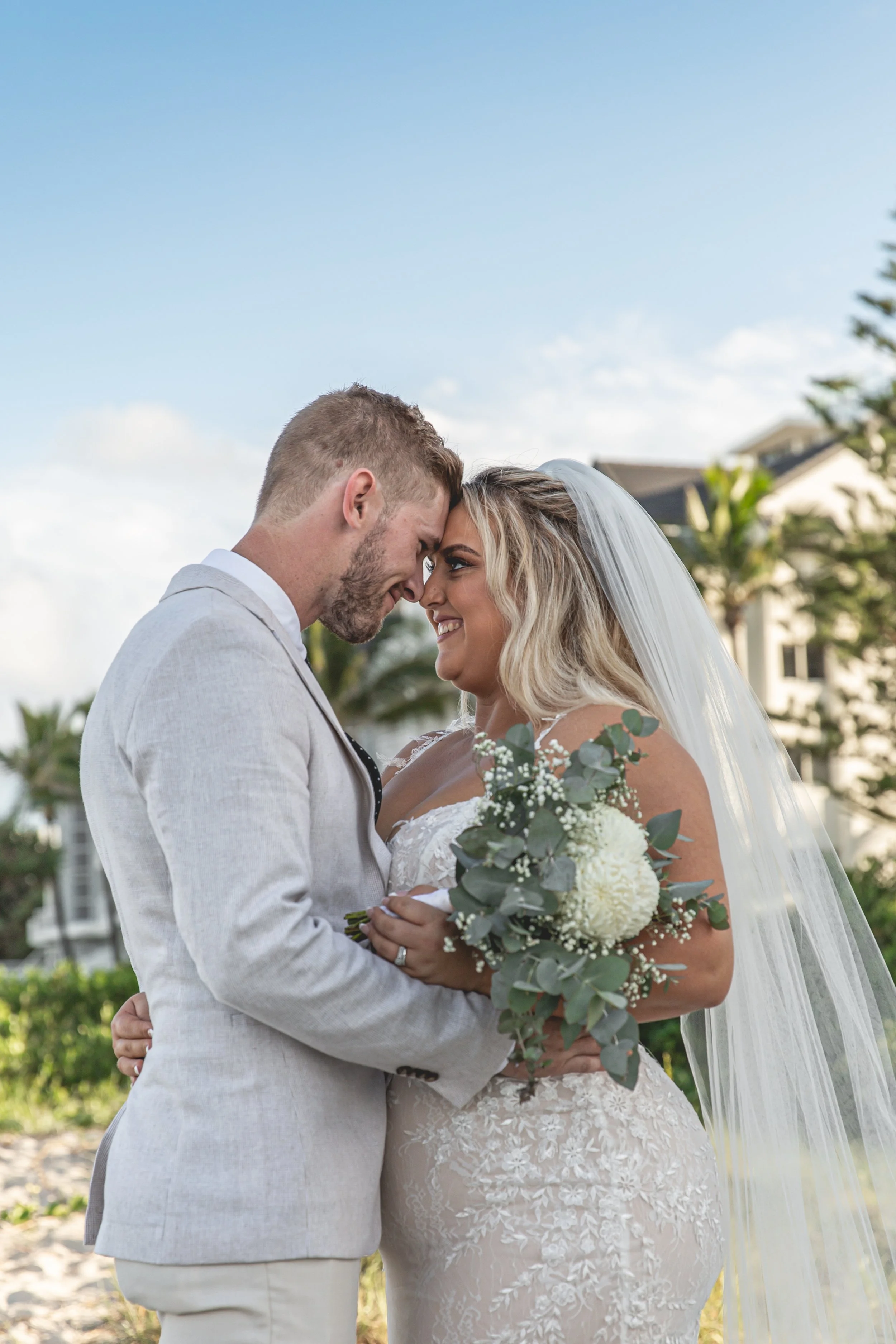 Couple hold each other close on Gold Coast Beach during their wedding. 
