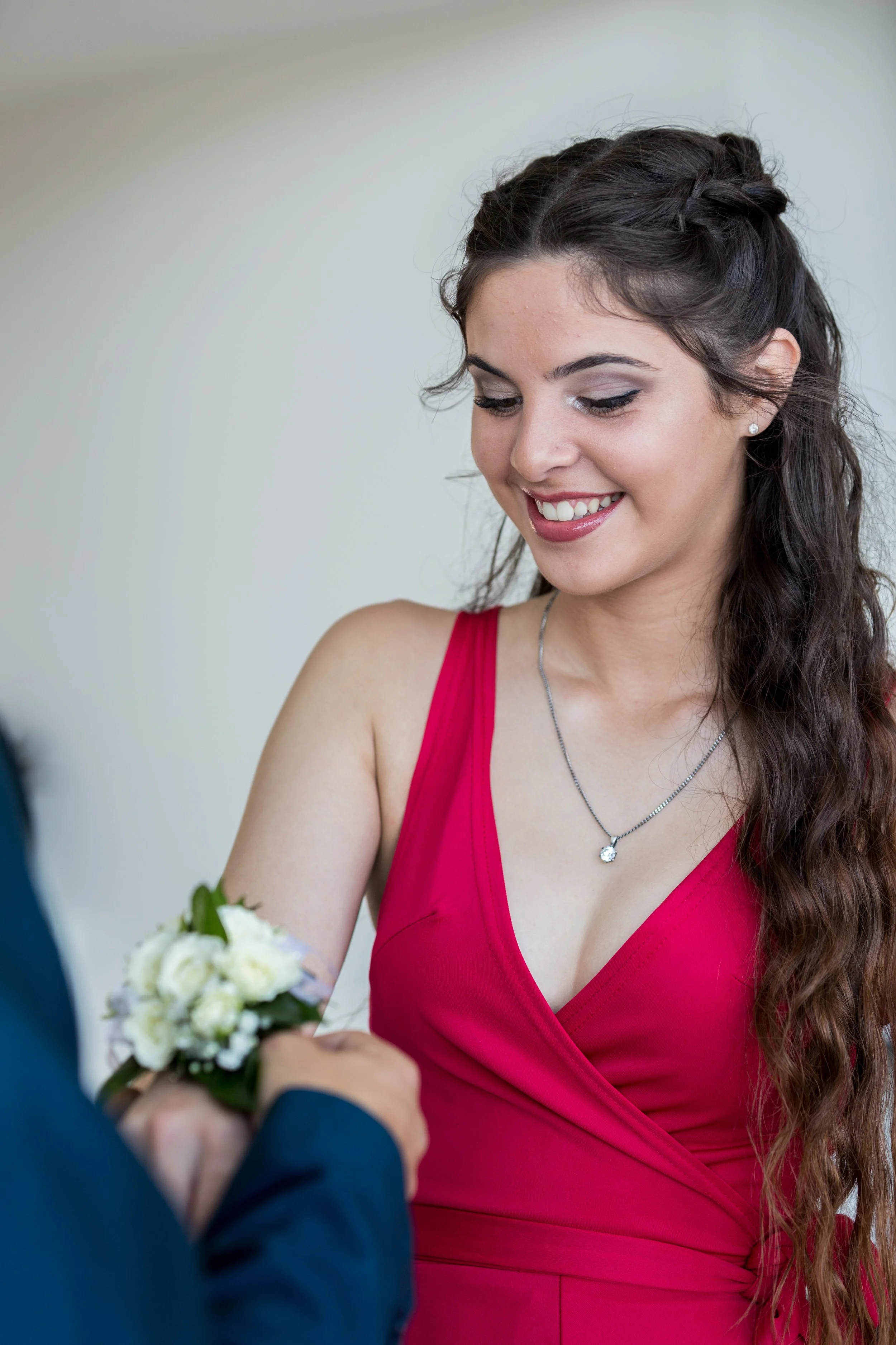 Male applies floral corsage to female for school formal.