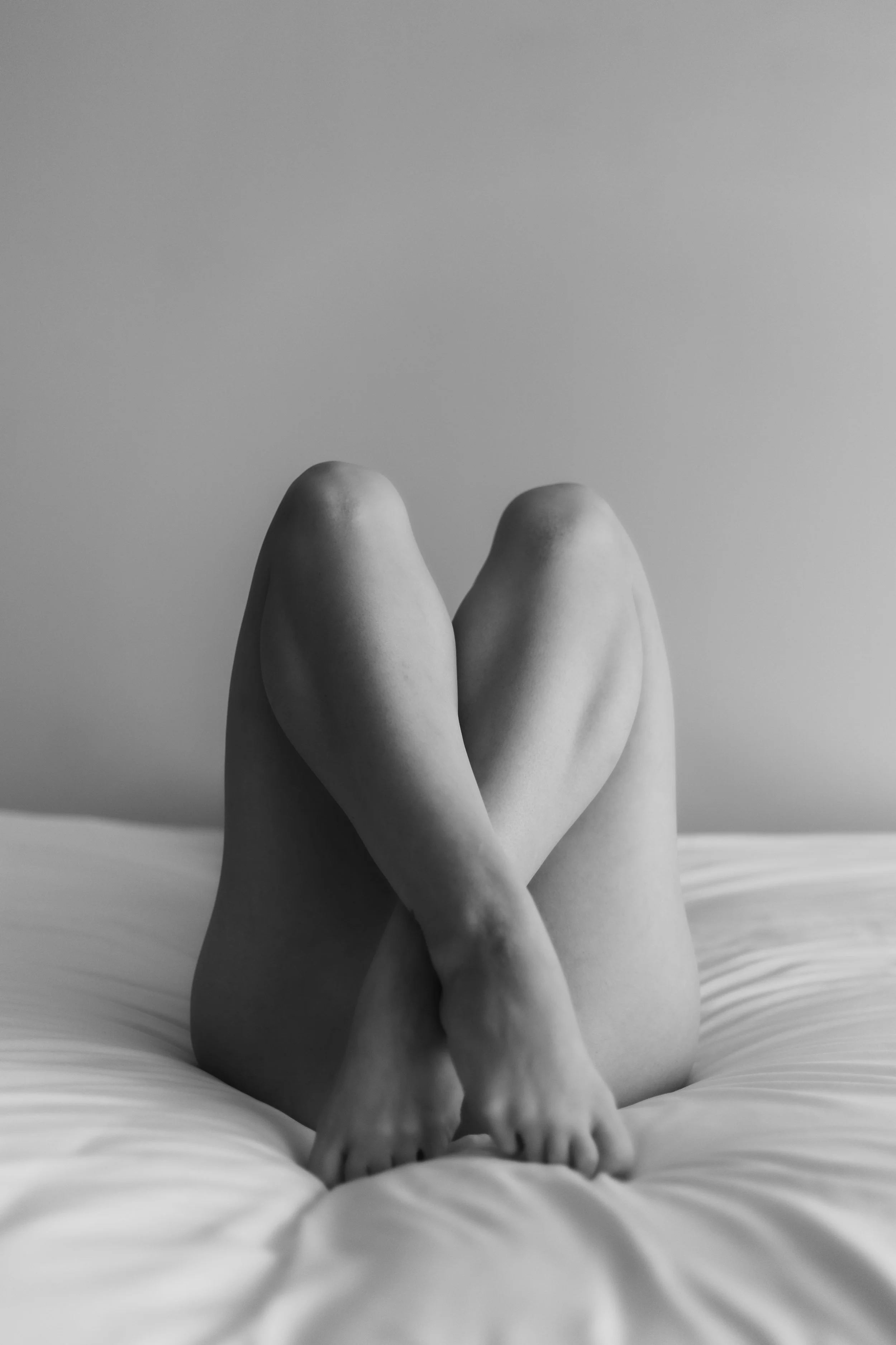 Legs cross in stunning black and white boudoir portrait. 