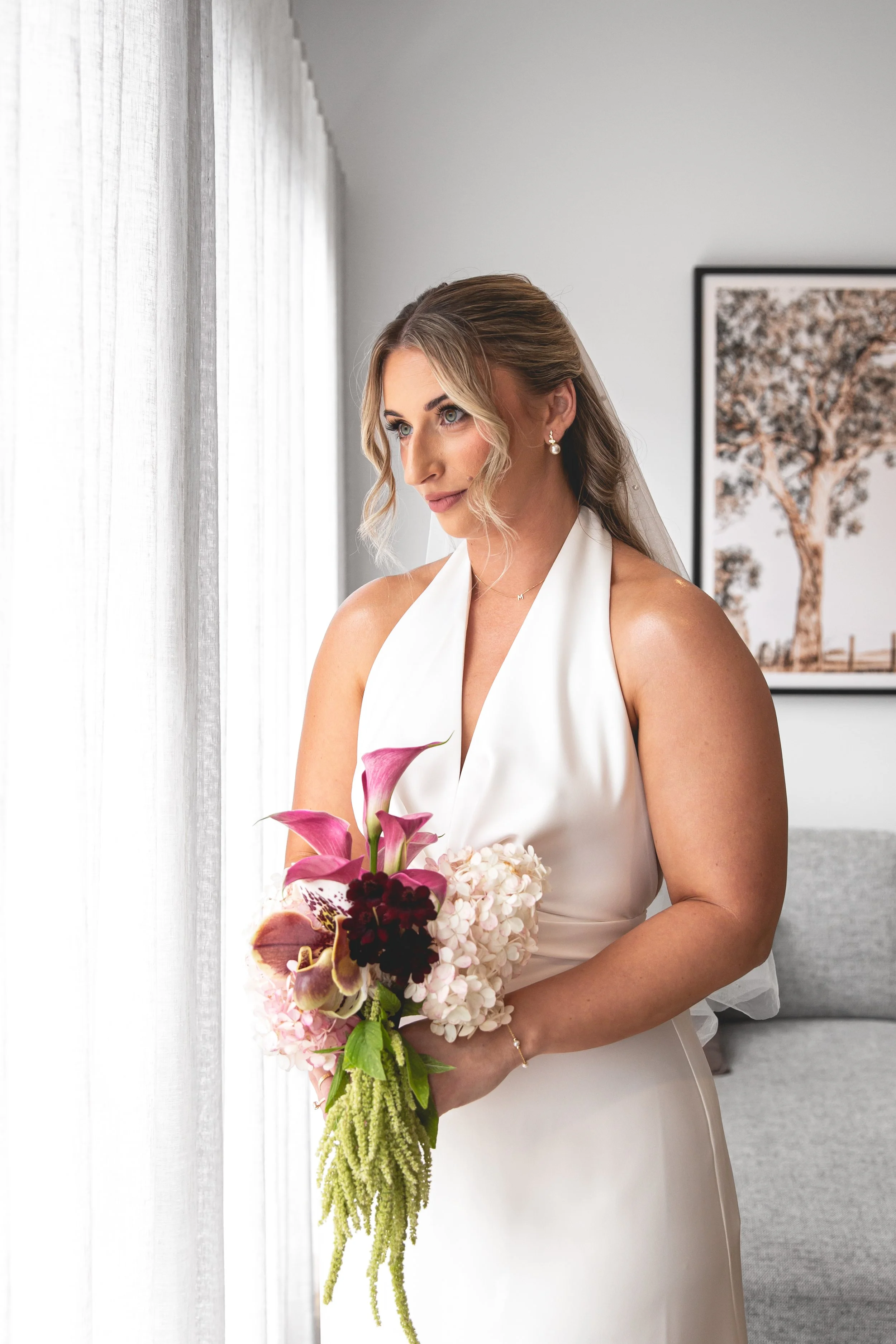 Portrait of woman in wedding gown holding bouquet admiring the view at Selah Valley Estate Creekside Lodge. 