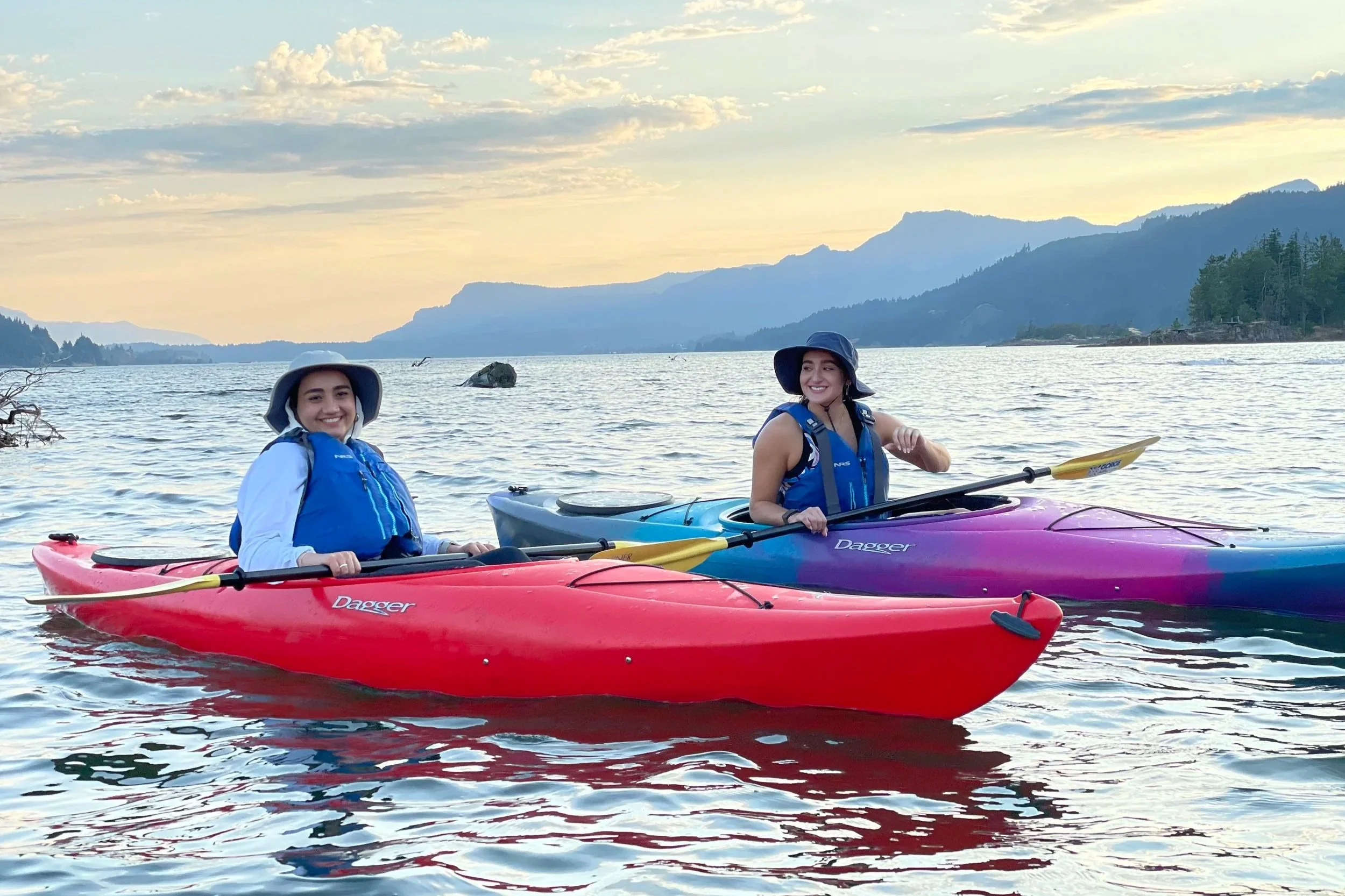 Two people kayaking on a the Columbia River at sunset in Cascade Locks, Oregon.