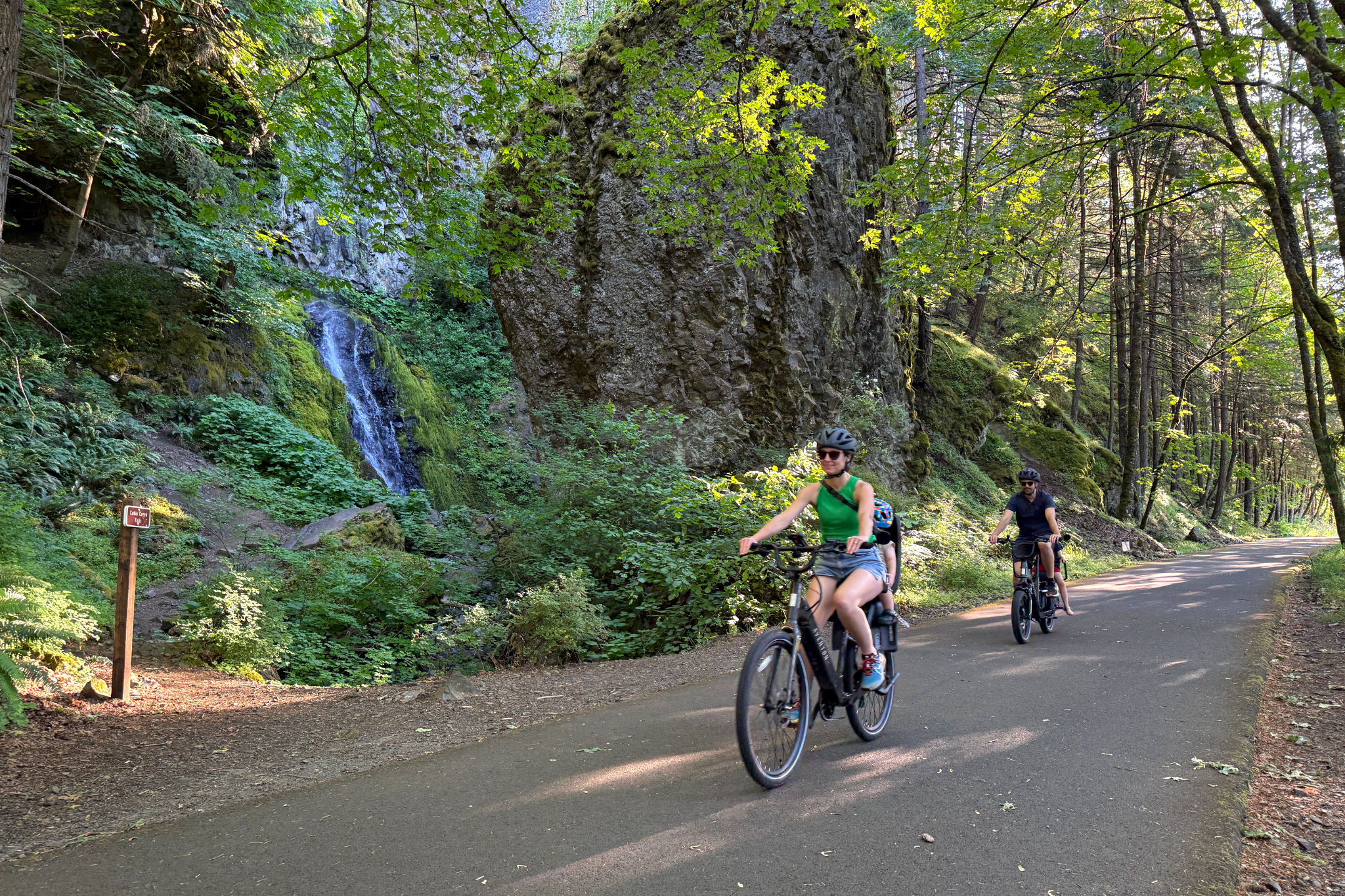 A family riding e-bikes on the Historic Columbia River Highway State Trail near Cascade Locks, Oregon.