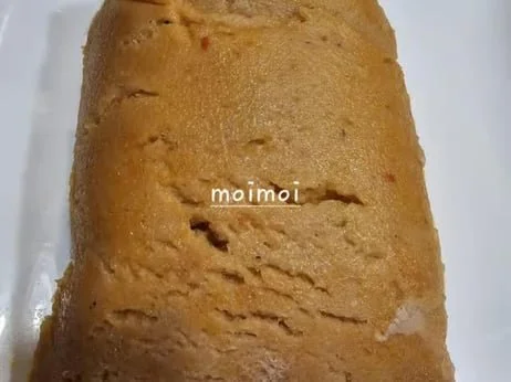 Close-up of a block of moimoi, an Indonesian steamed bean cake, with the word 'moimoi' written on it.
