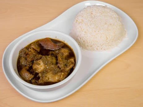 Plate with rice and beef stew on a wooden surface