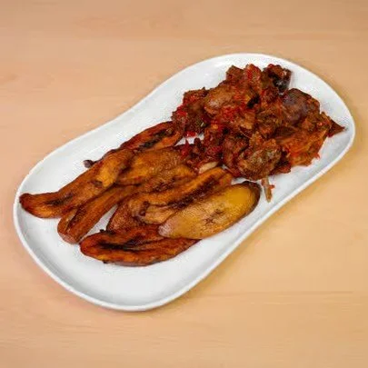 Plate with cooked fried plantains and a meat stew