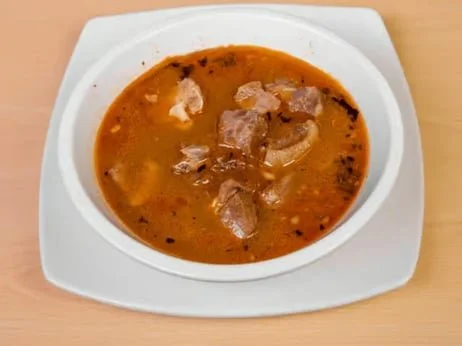Bowl of beef stew with chunks of beef and vegetables on a white plate