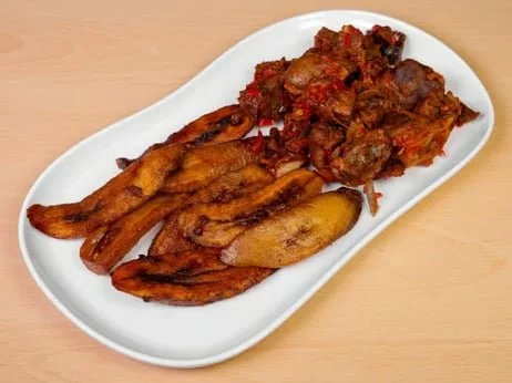 Plate with fried plantains and cooked meat stew