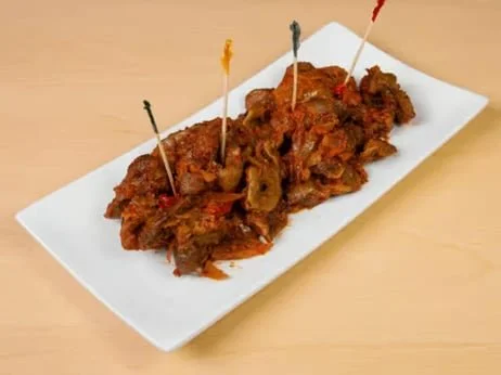 Fried chicken wings on a white rectangular plate with colorful toothpicks.