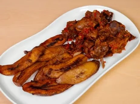 Fried chicken wings and cooked meat on a white oval plate
