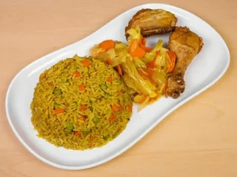 Plate of yellow rice with vegetables, and beans with collard greens