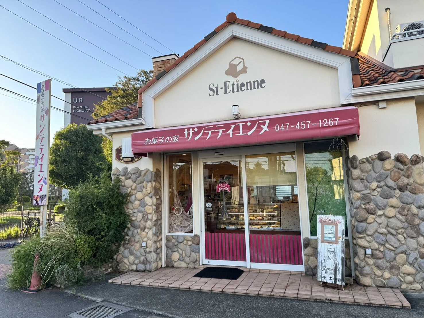 小さなケーキ屋の外観、看板に「サンテティエンヌ」、窓からケーキが見える。