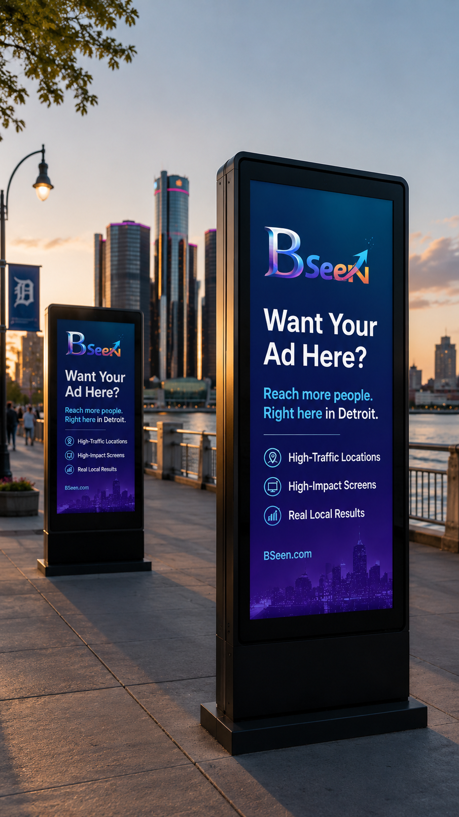 Two digital advertising billboards on a city sidewalk in Detroit promoting advertising services. The larger billboard shows the message, "Want Your Ad Here? Reach more people. Right here in Detroit," with icons and text for high-traffic locations, high-impact screens, and real local results. The background features a city skyline and sunset sky.
