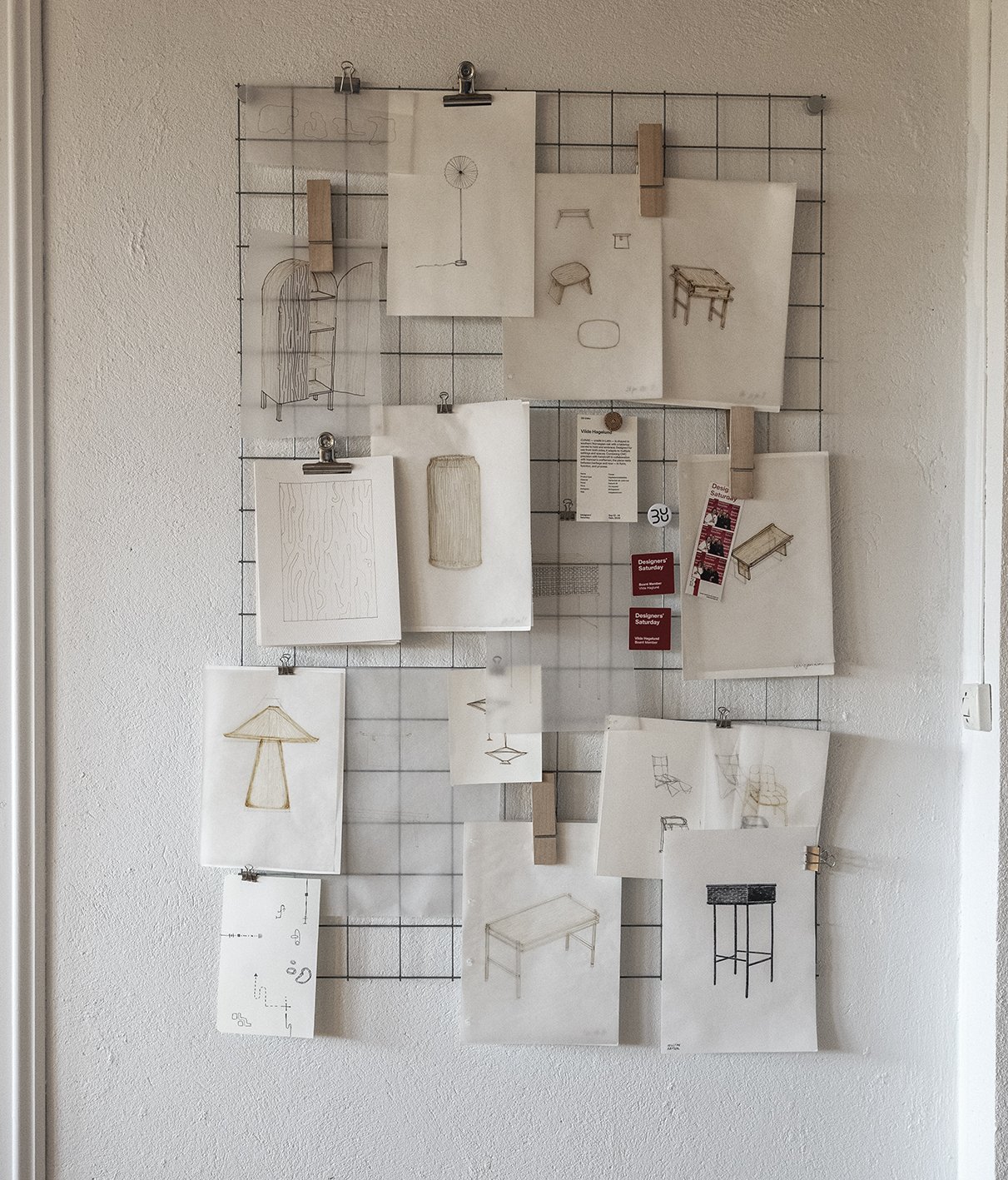 Moodboard with sketches of furniture and design ideas pinned on a wire grid.