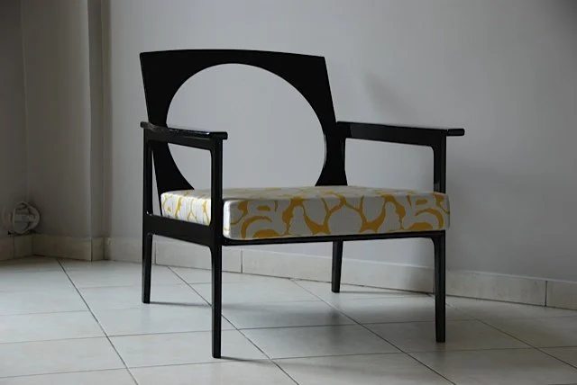Un meuble de style moderne avec une assise rembourrée à motif jaune et blanc, placé contre un mur blanc dans une pièce.