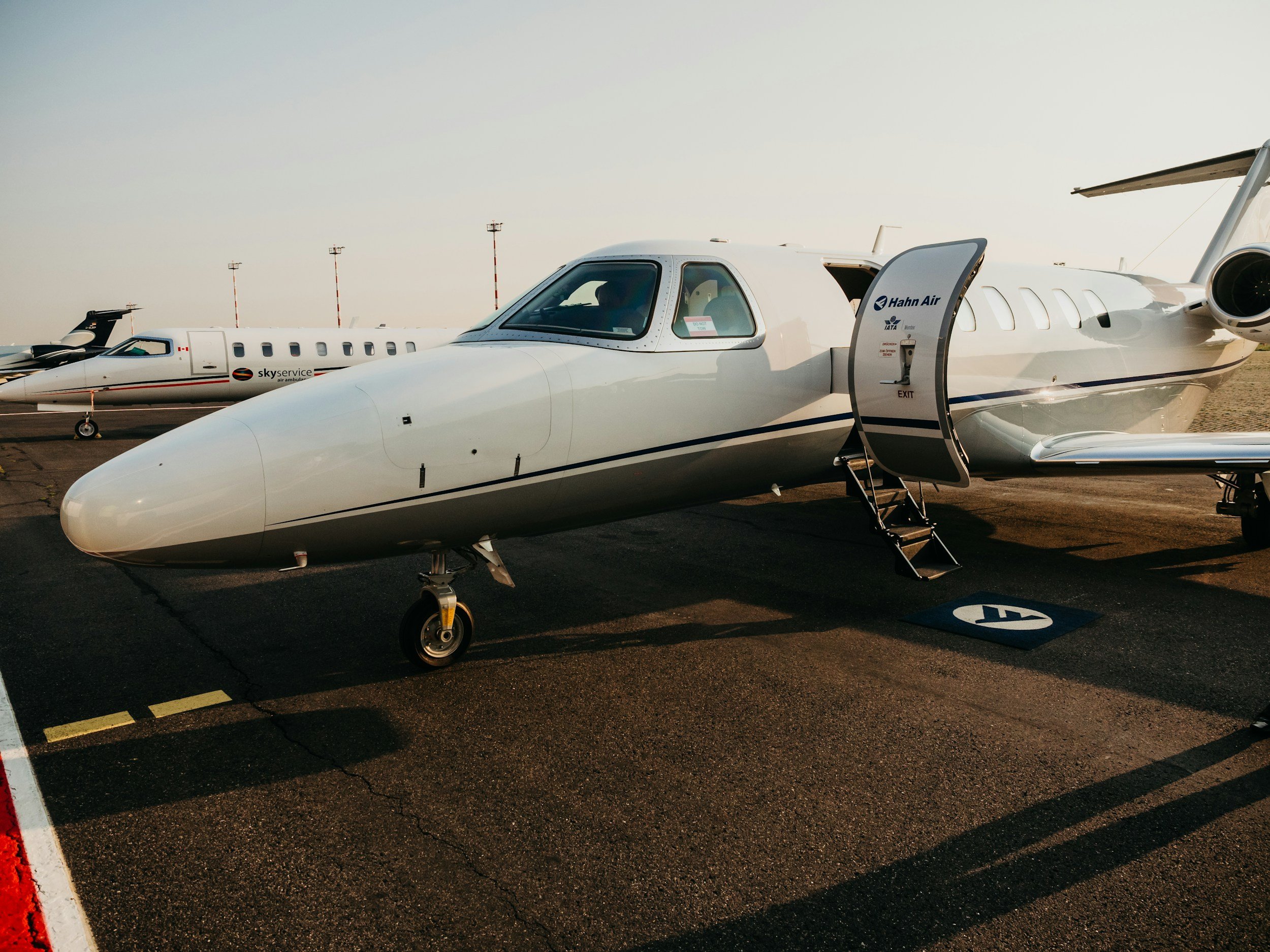 Corporate private jets parked on the airport tarmac undergoing professional multi-stage aircraft paint correction.