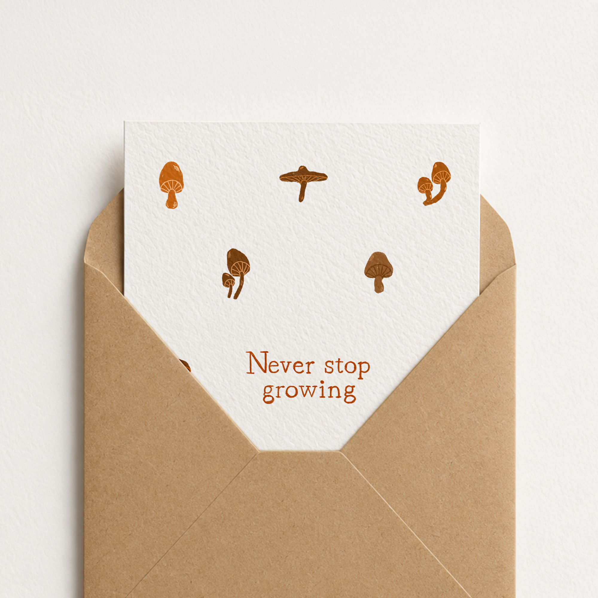 Minimalist greeting card featuring brown mushroom illustrations and the text Never stop growing, original art by Kadna Anda.
