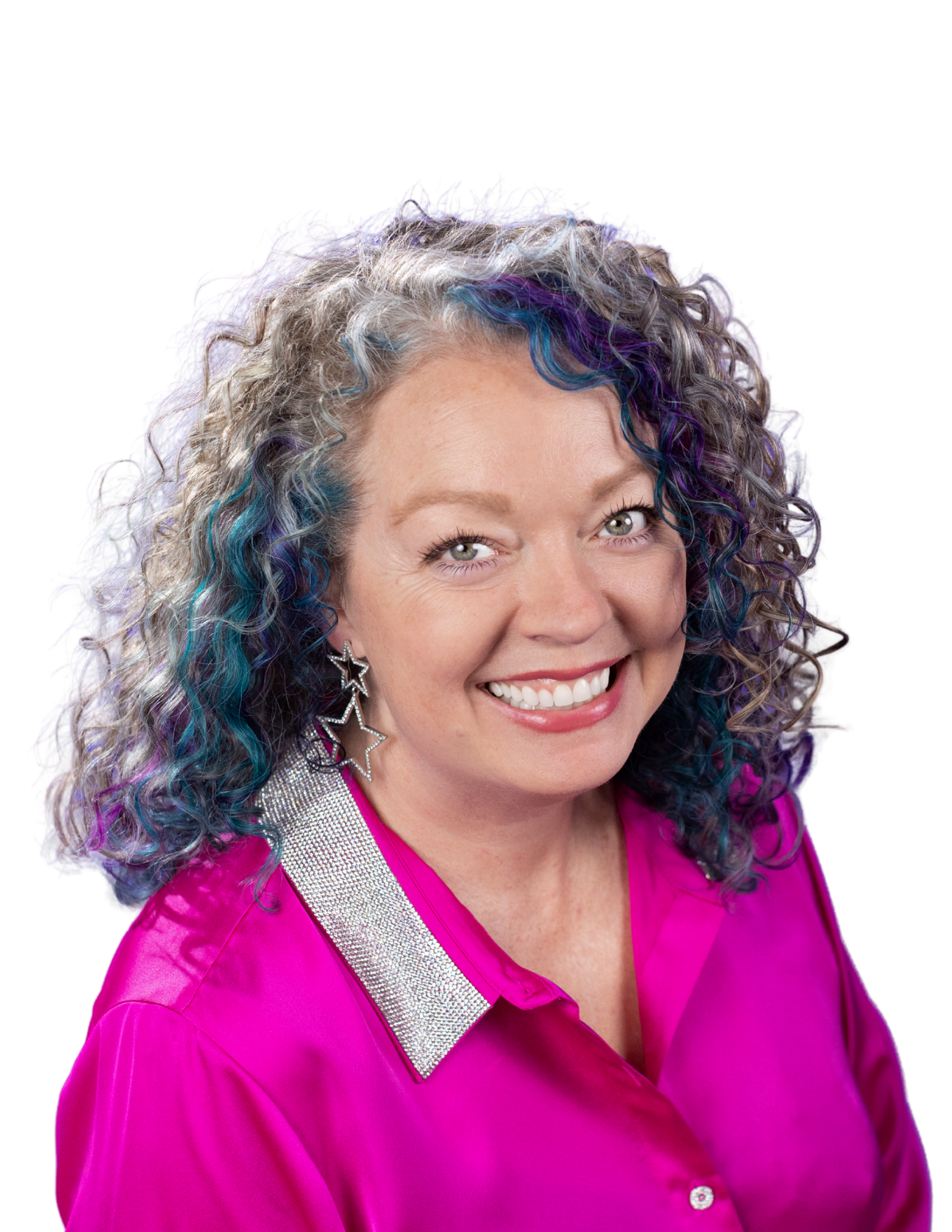 A smiling woman with curly hair featuring purple, blue, and blonde highlights, wearing a bright pink top with a silver strap and star earrings.