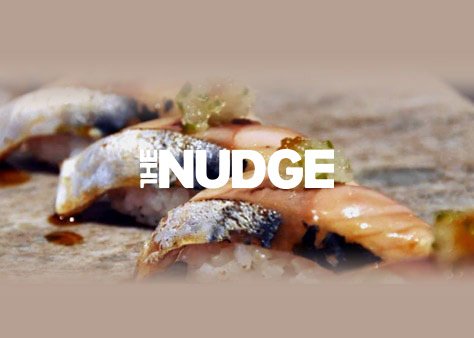 Close-up of sushi with text overlay that reads "The Nudge".