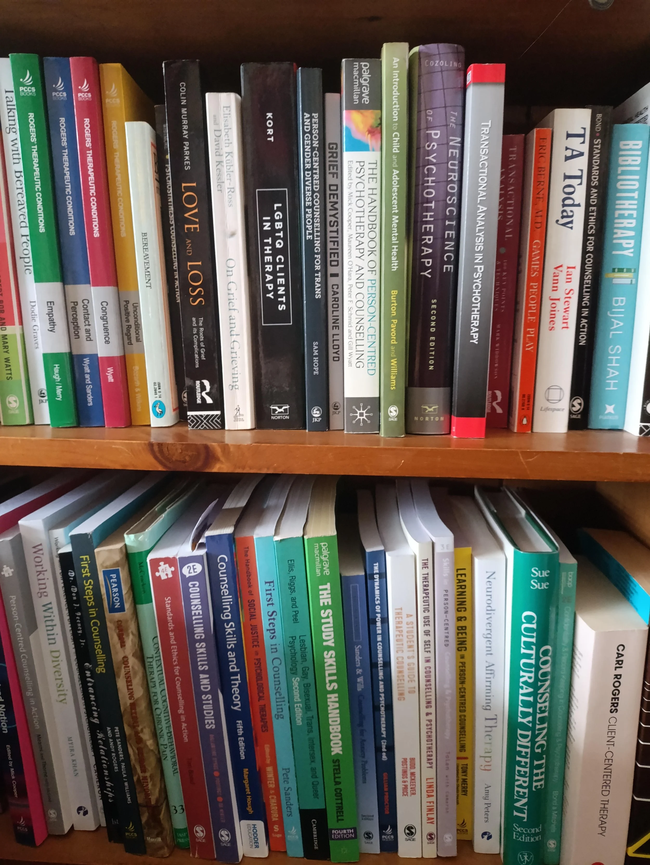 A bookshelf filled with various psychology, counseling, and therapy books arranged vertically with their spines outward.