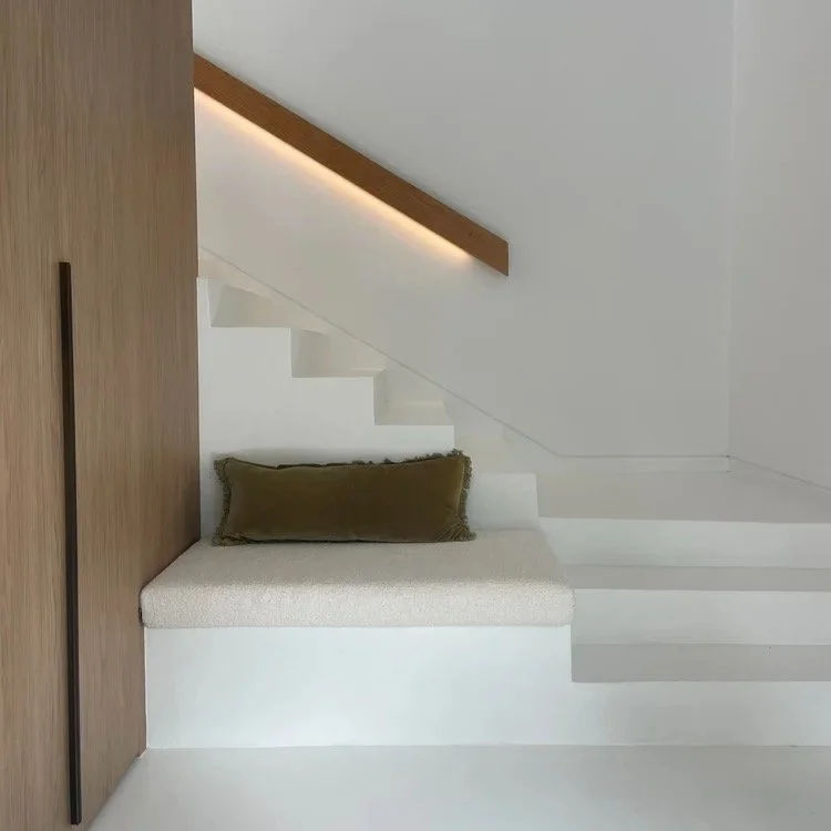 timber built in storage and a seat at the bottom of a staircase with custom handrail