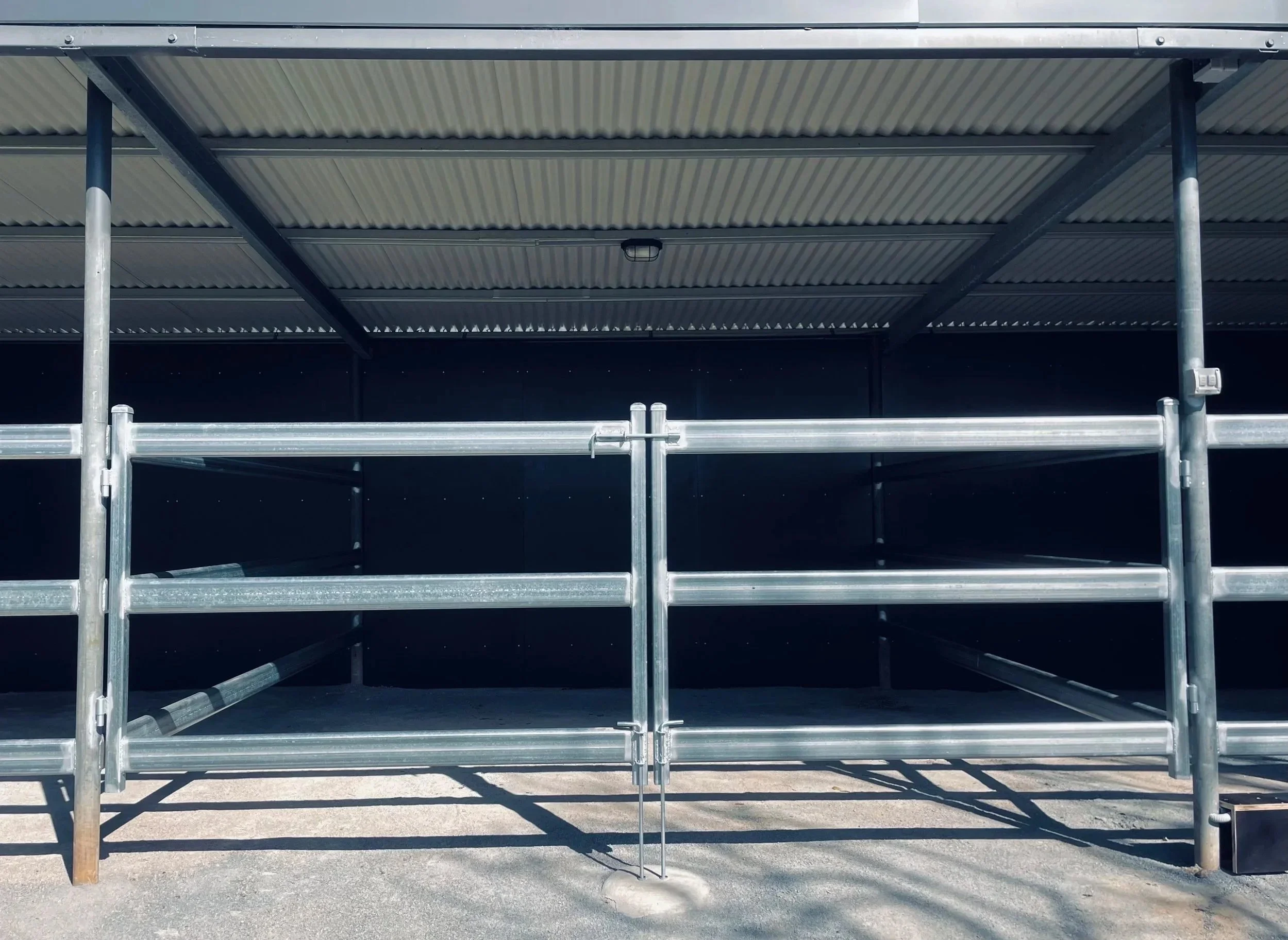 animal barn and stables created by galvanised steel railings, lockable swing gates and metal sheet sides and roof.