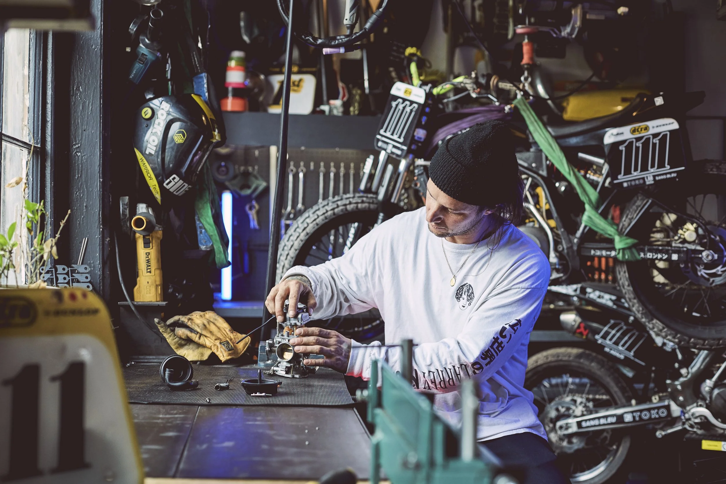 Custom motorbike design studio with workbenches and tool organisation wall