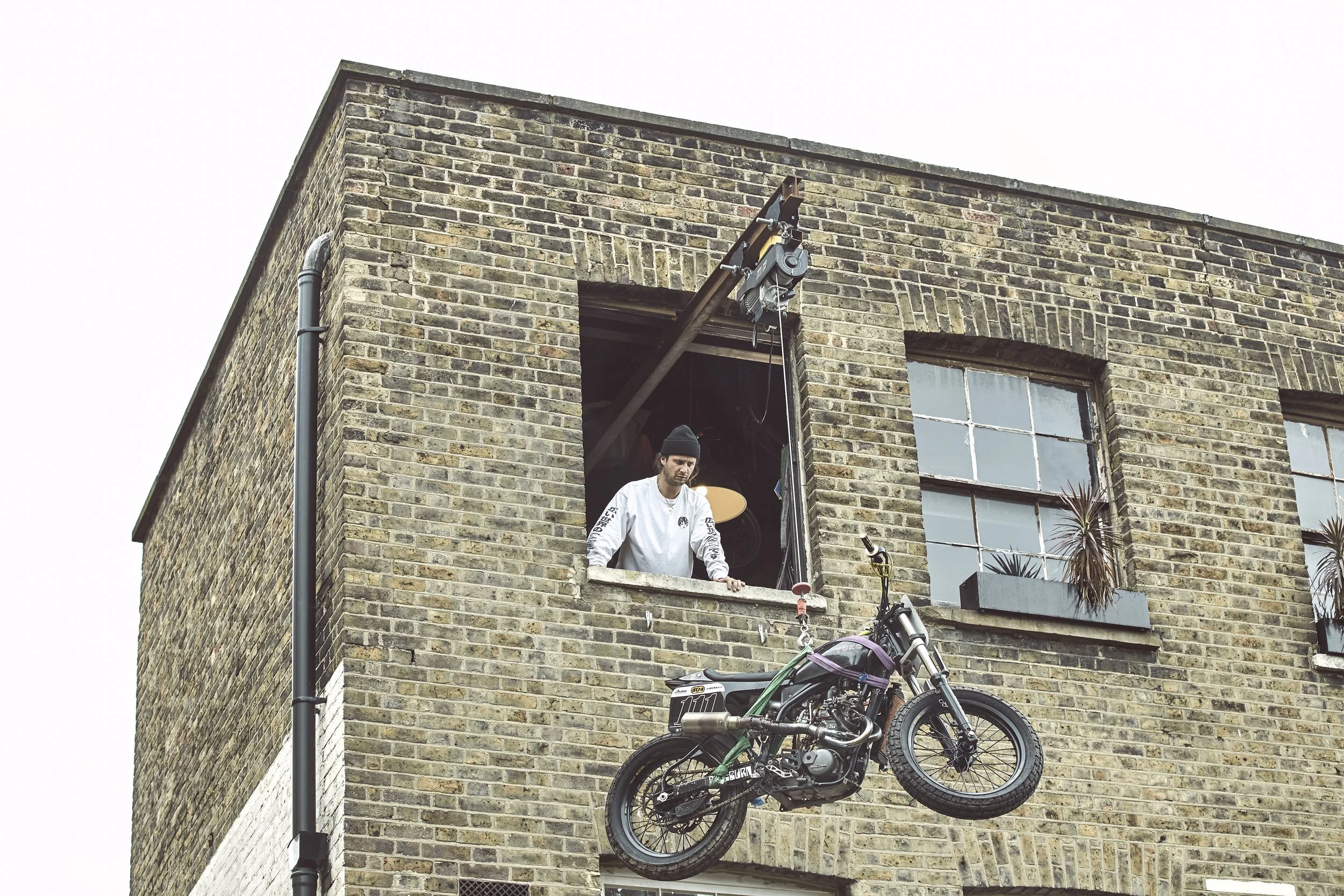 bespoke industrial electric winch hoist lifting a motorcycle into a building 