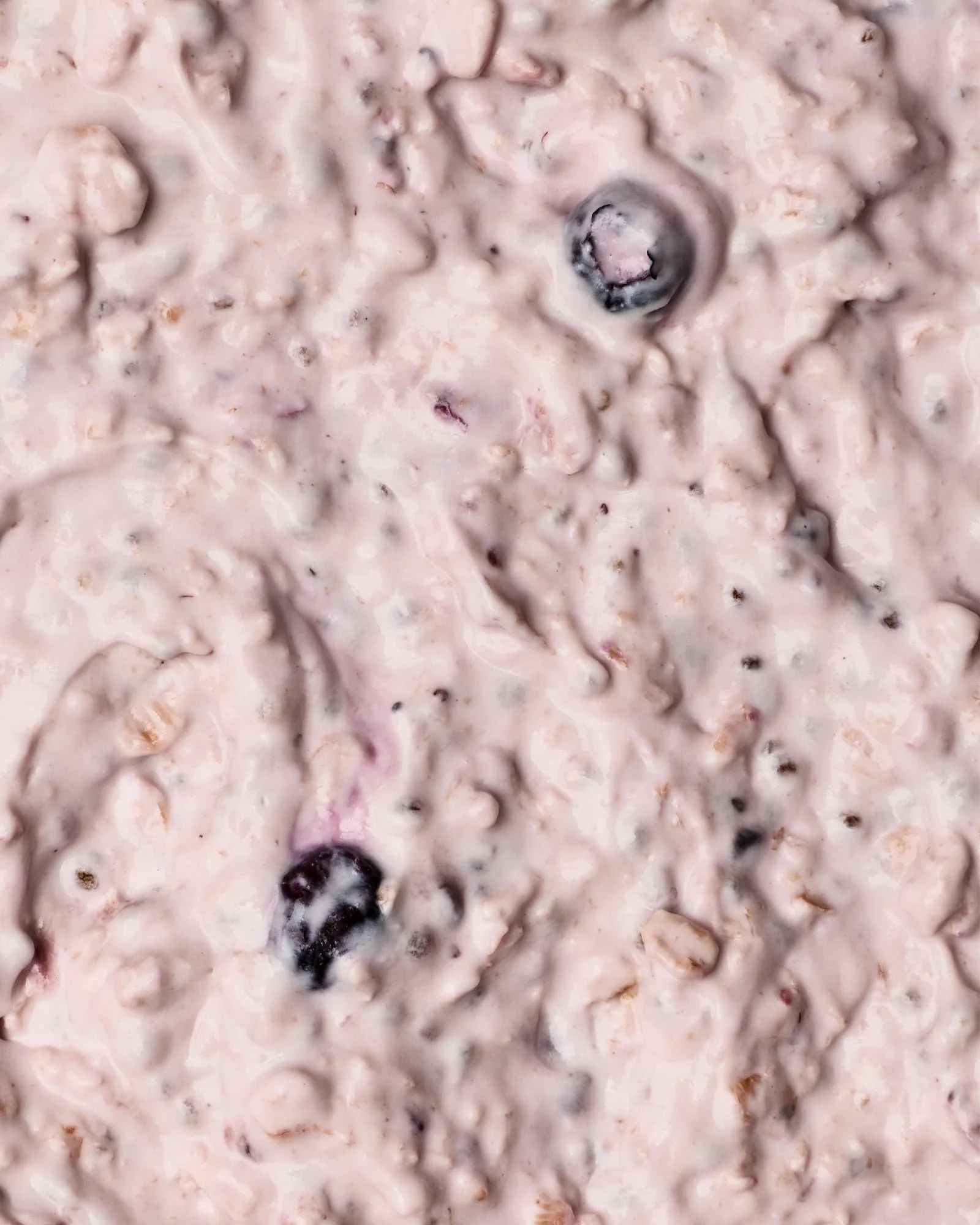 Close-up of blueberry muffin batter with blueberries mixed in.