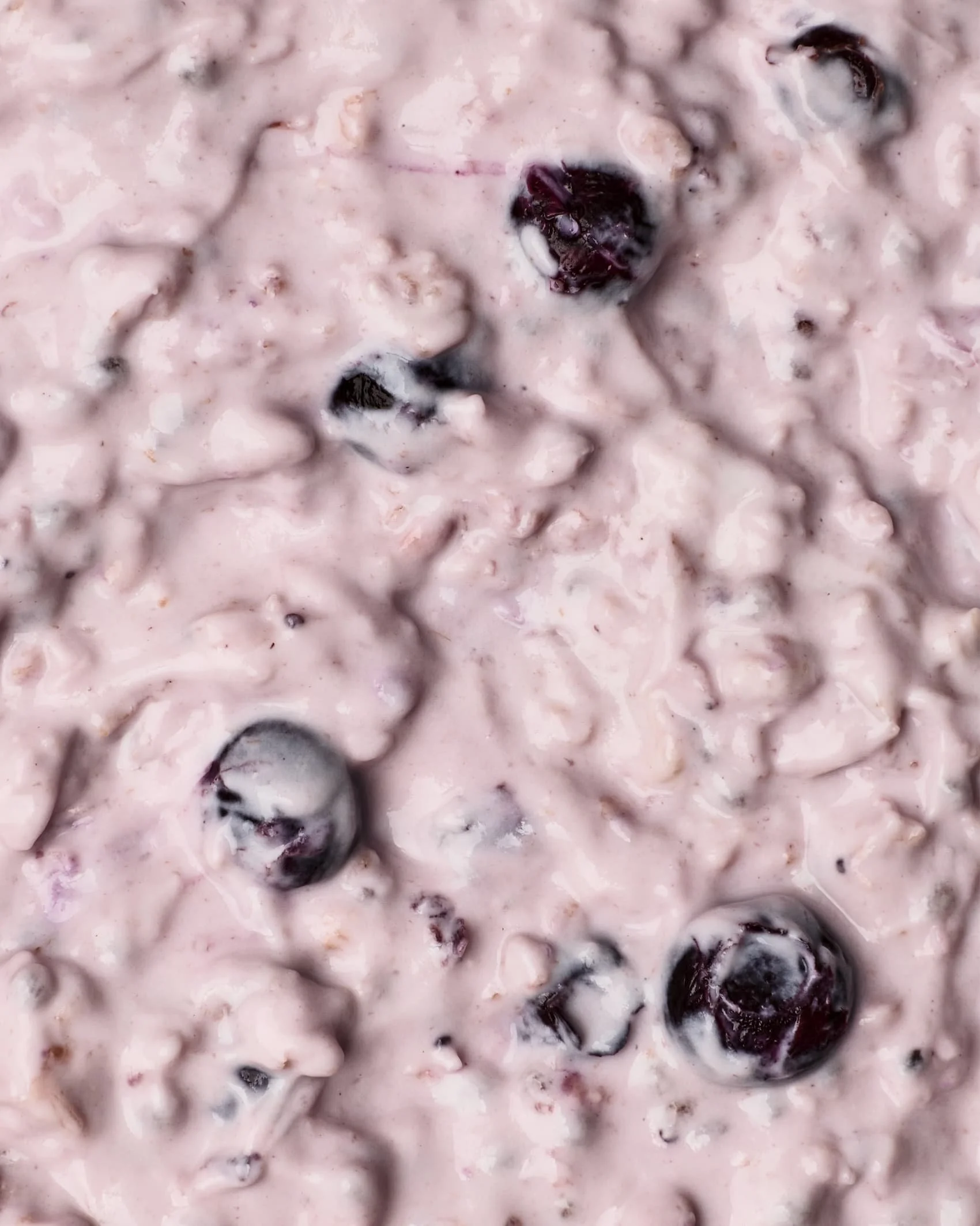 Close-up of a mixture with blueberries and cream or yogurt.