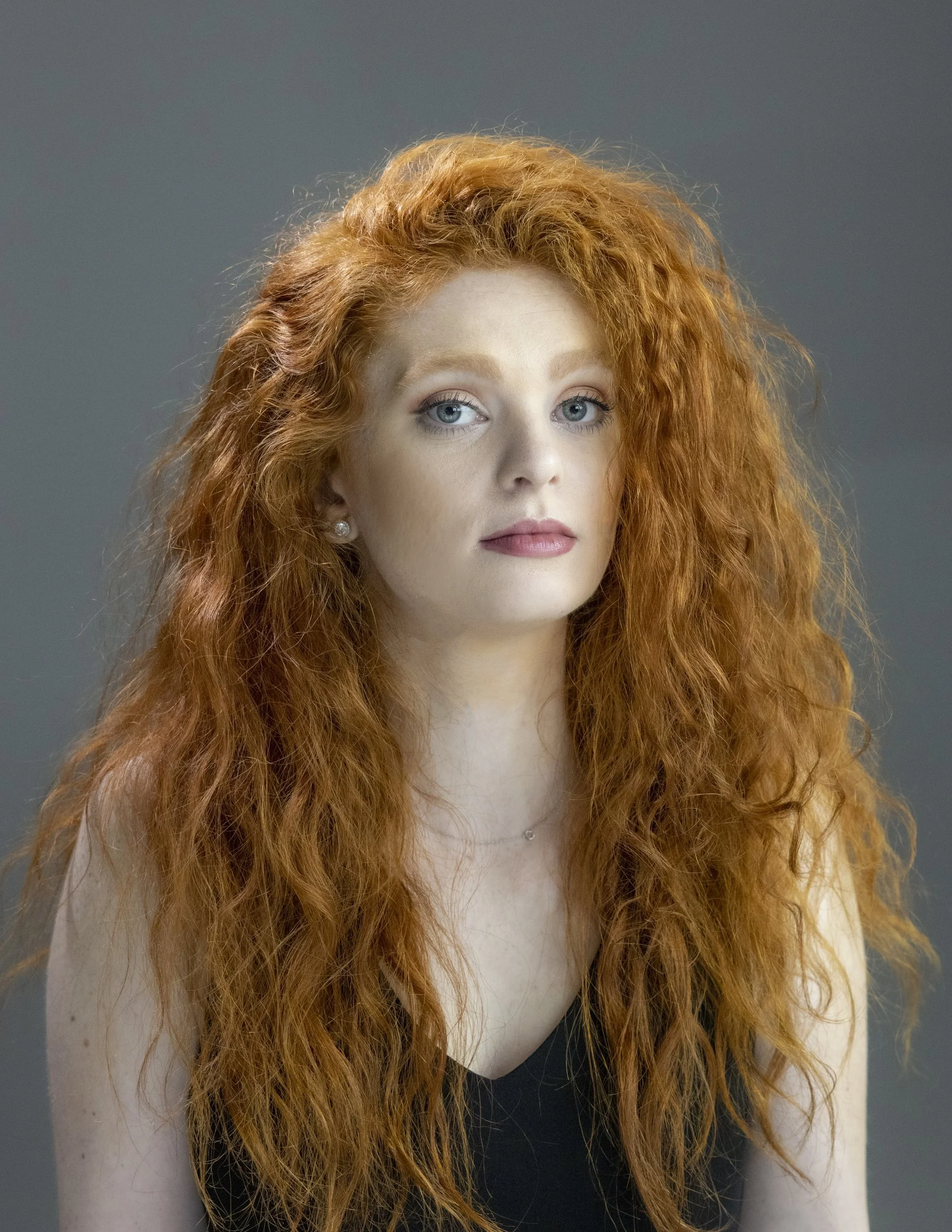 Professional headshot of a young woman with long red curly hair, IKON headshot by Soulmarks in Dexter, Missouri