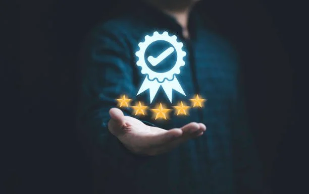 Mano che tiene un'icona luminosa di un sigillo di qualità con stelle dorate sottostanti.